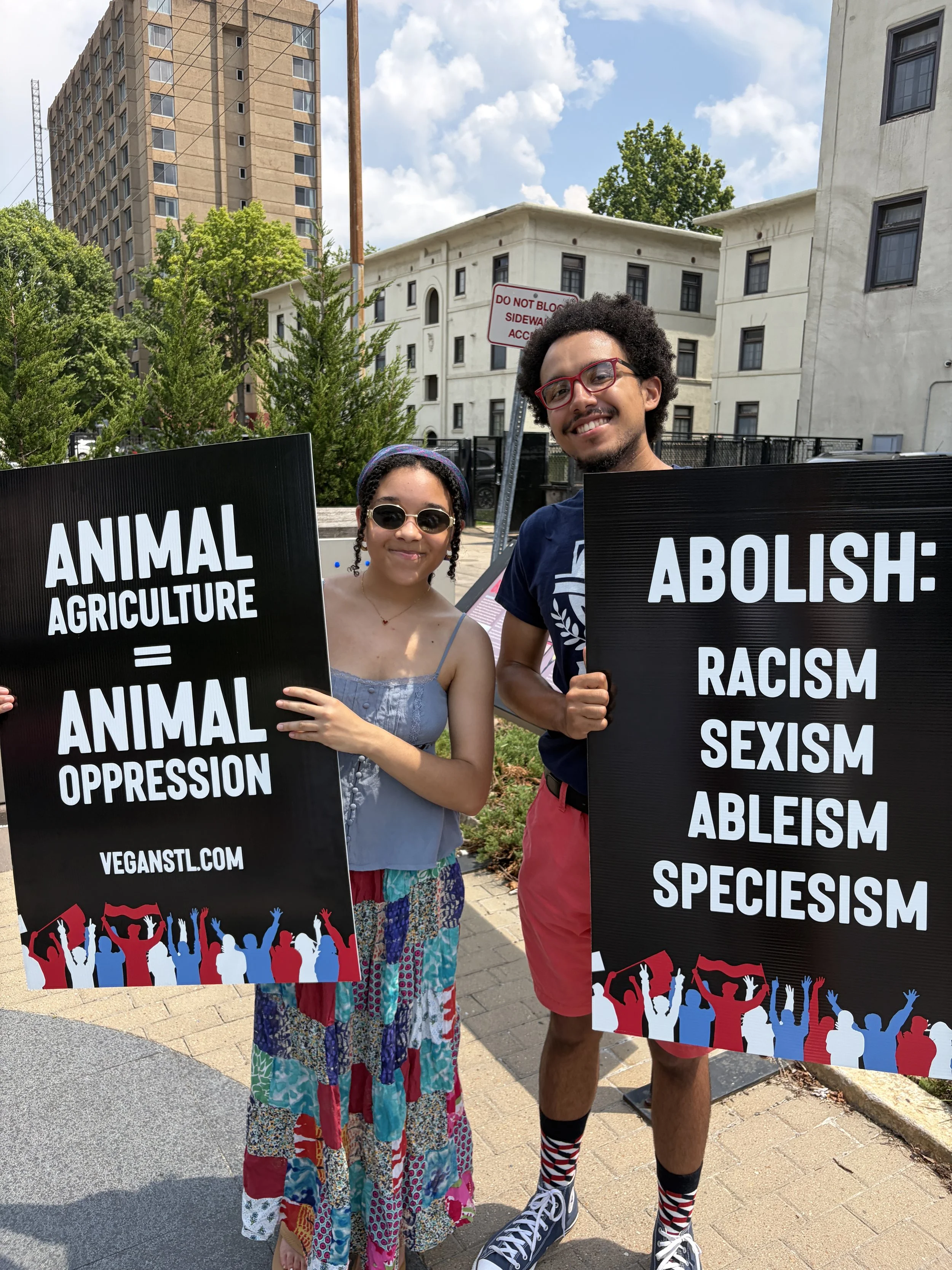 Adrianne holding a sign stating that animal agriculture is animal oppression at our Animal Freedom March