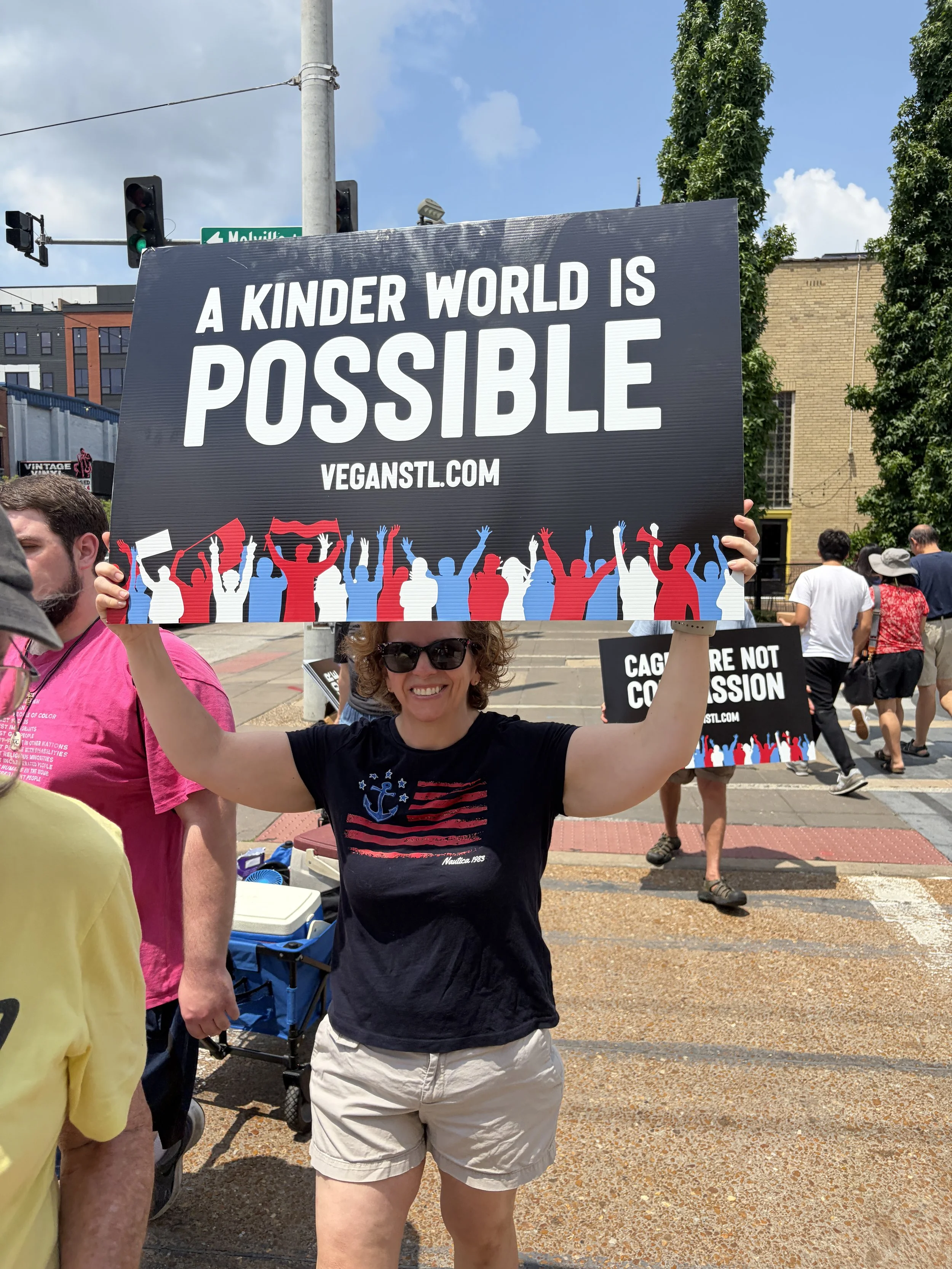 Jenna Luzynski holding a sign that states a kinder world is possible while at our Animal Freedom March