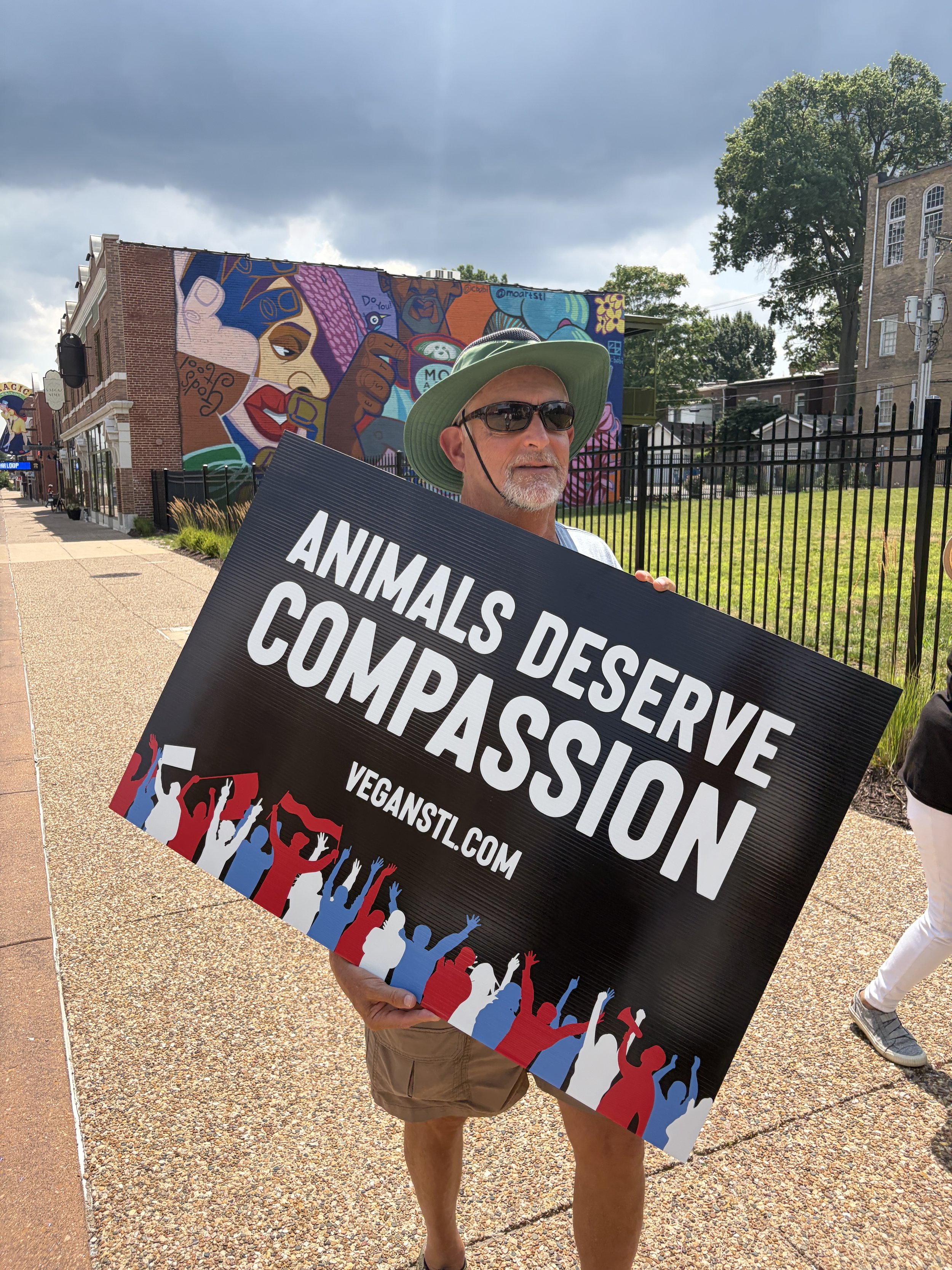 Rick carrying a sign that states animals deserve compassion while marching in our Animal Freedom March