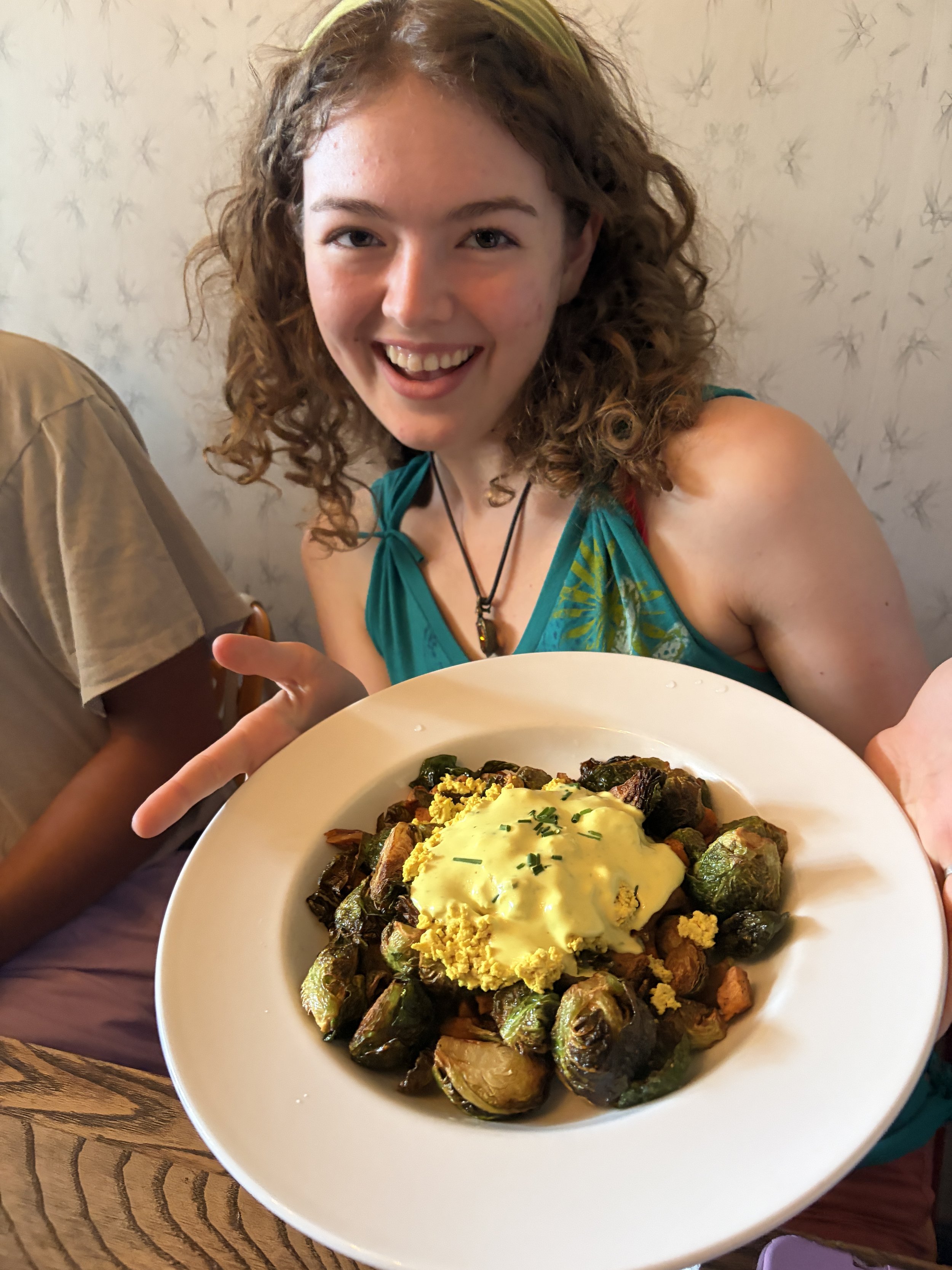 Event attendee enjoys plant-based brussel sprouts dish at Vegan Brunch @ Tree House in St. Louis, Missouri.png