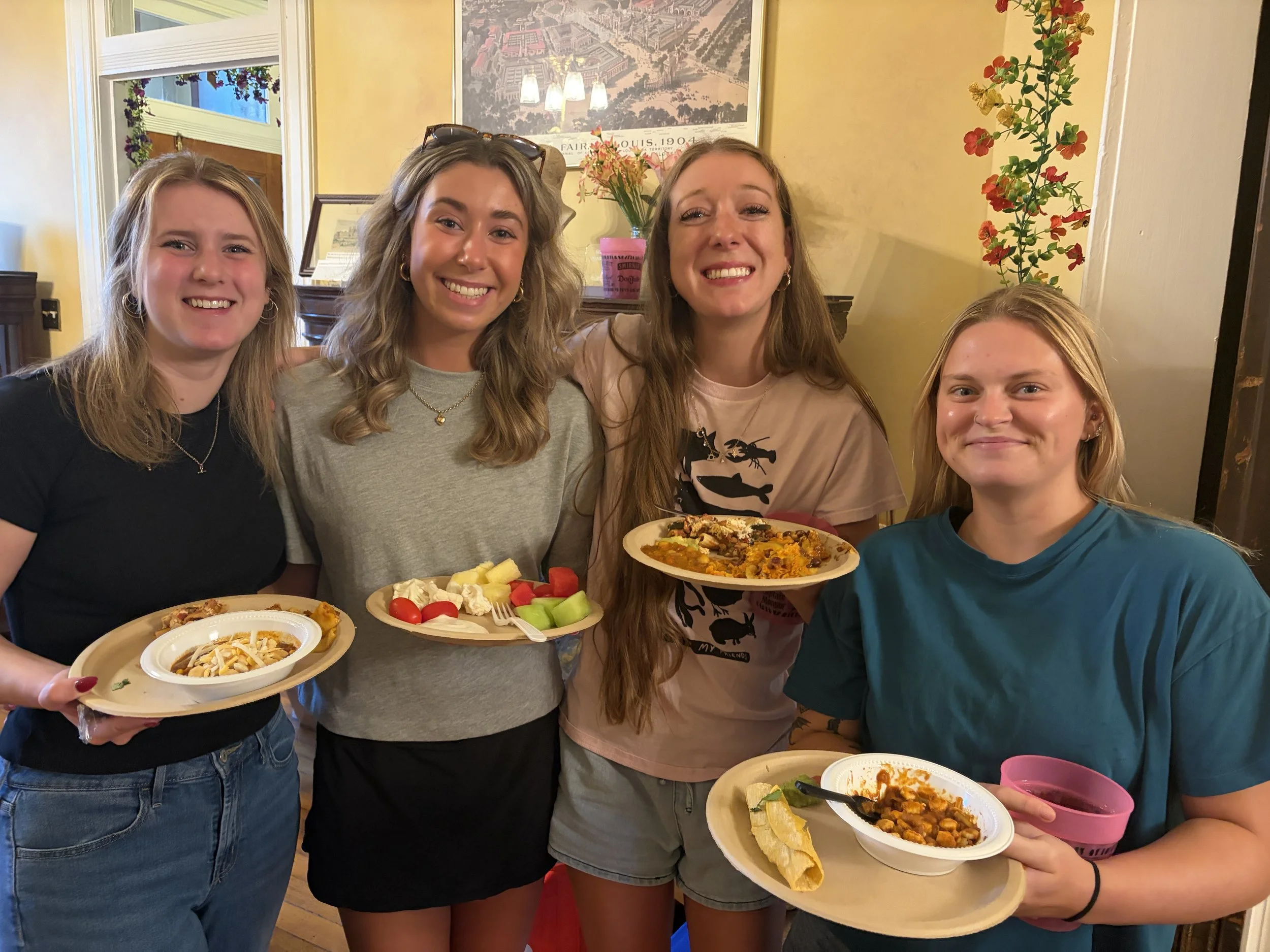 Group of attendees smile with plates full of vegan goodness at Plant Lovers Potluck in St. Louis, Missouri.png