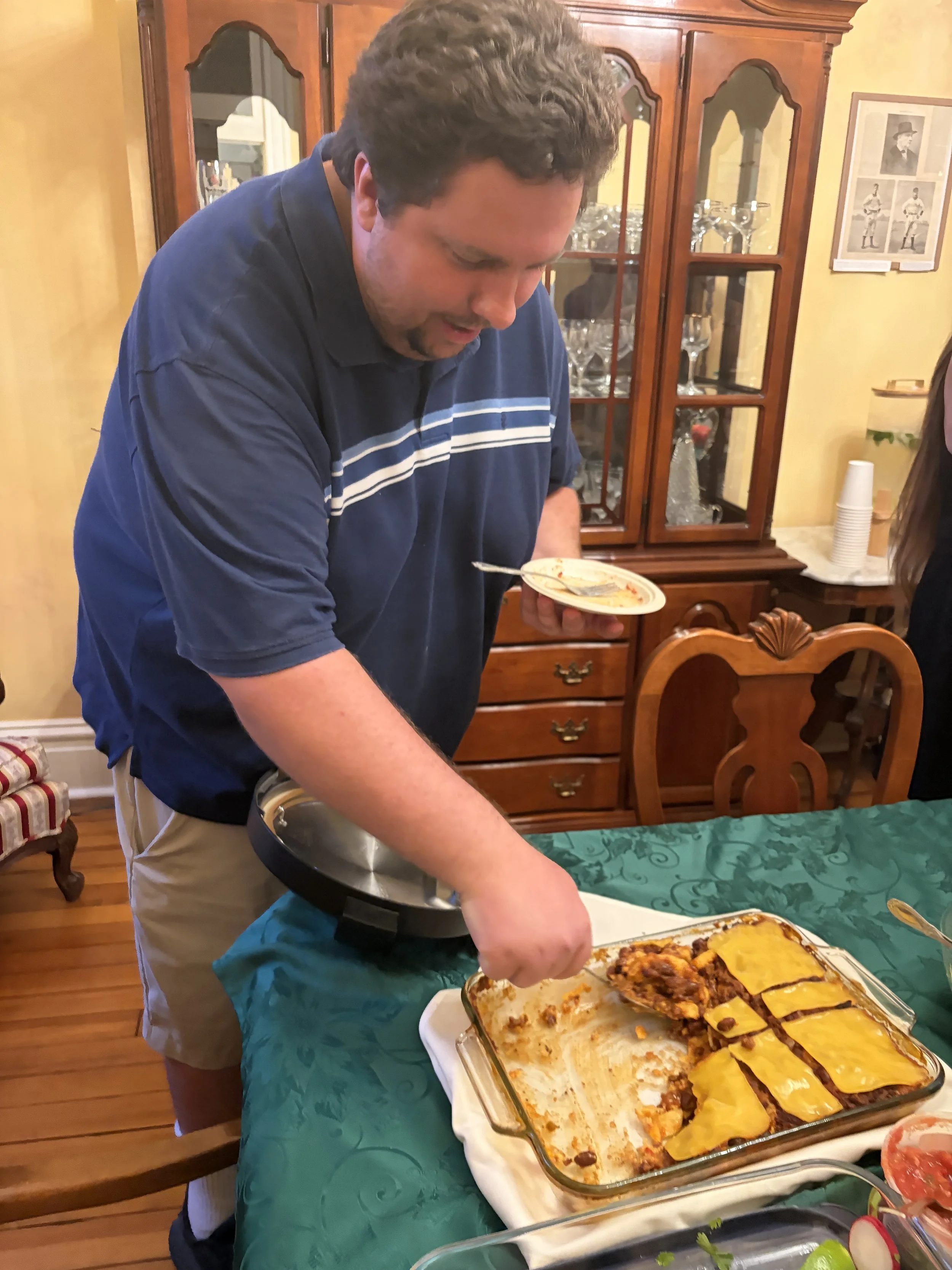Kyle, Executive Director of Project Animal Freedom, cuts a slice of vegan polenta at Plant Lovers Potluck.png
