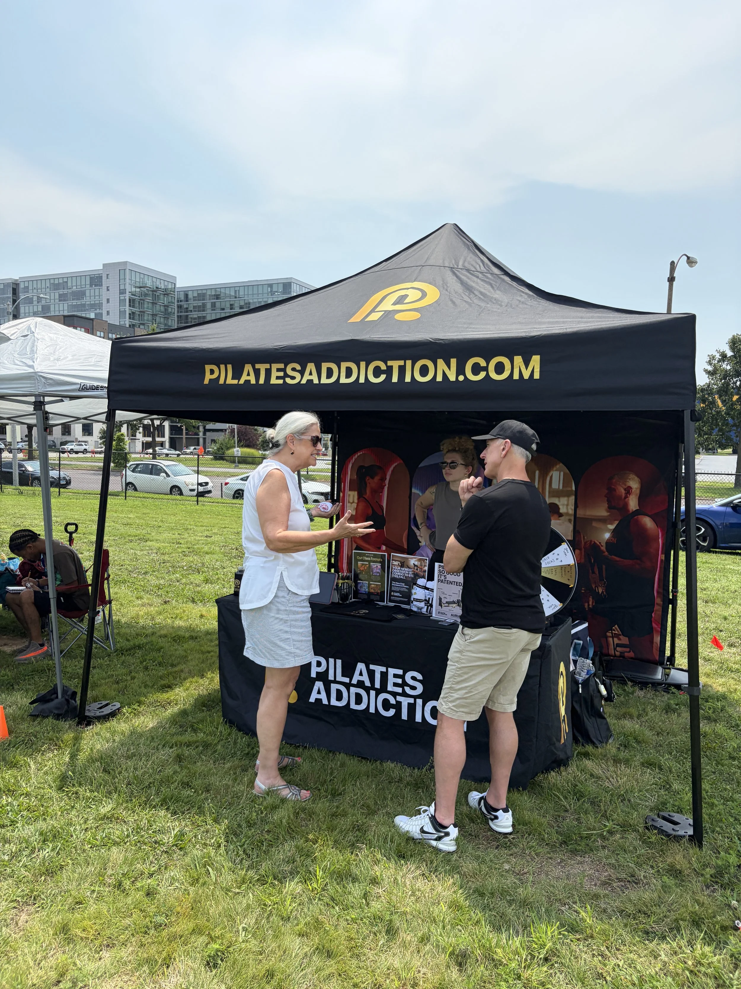 Client and customer chat at Pilates Addiction booth at STL Vegan Market in St. Louis, Missouri.png
