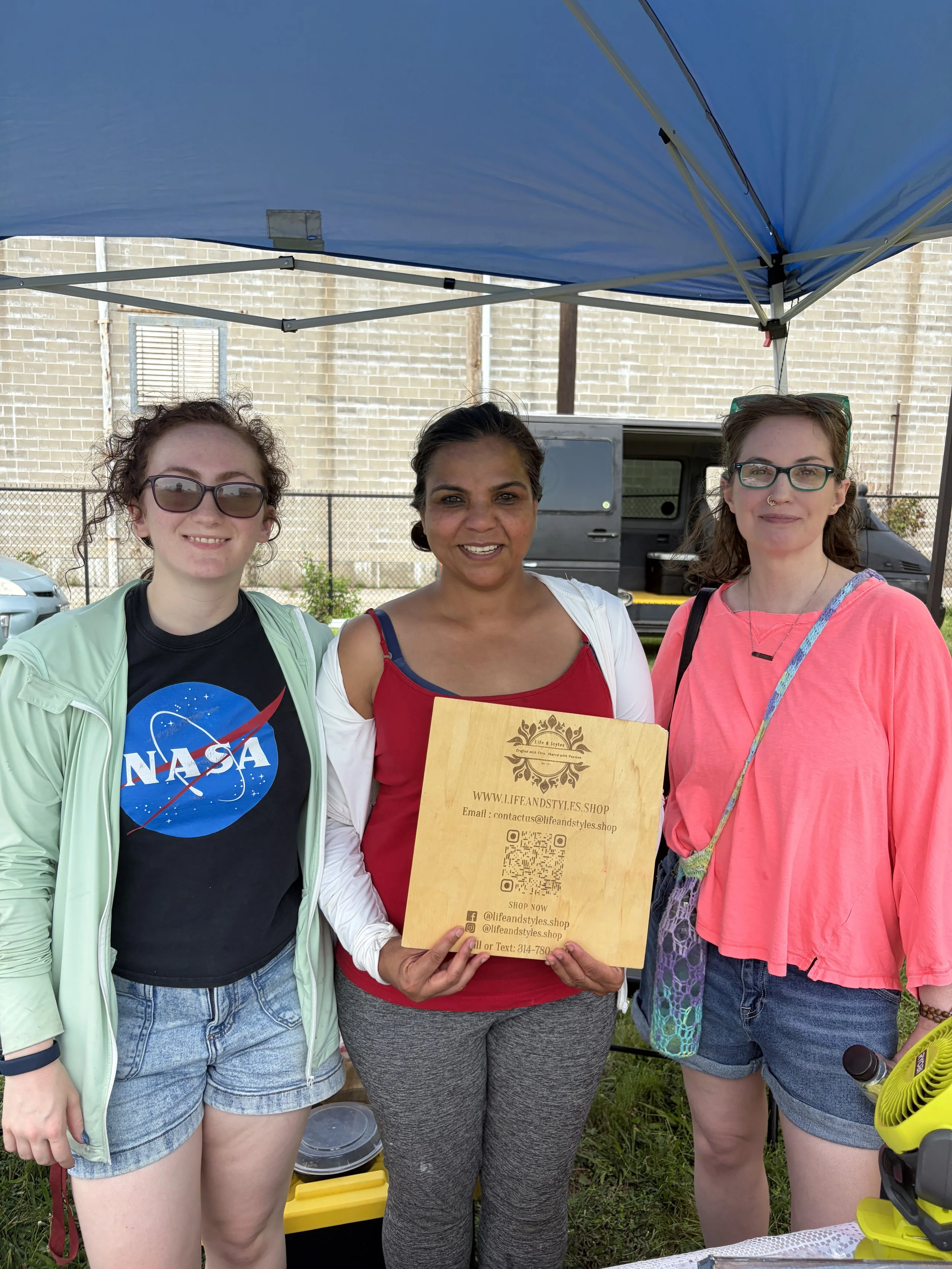 Priyaah and friends of Life & Styles take picture at booth for STL Vegan Market in St. Louis, Missouri.png