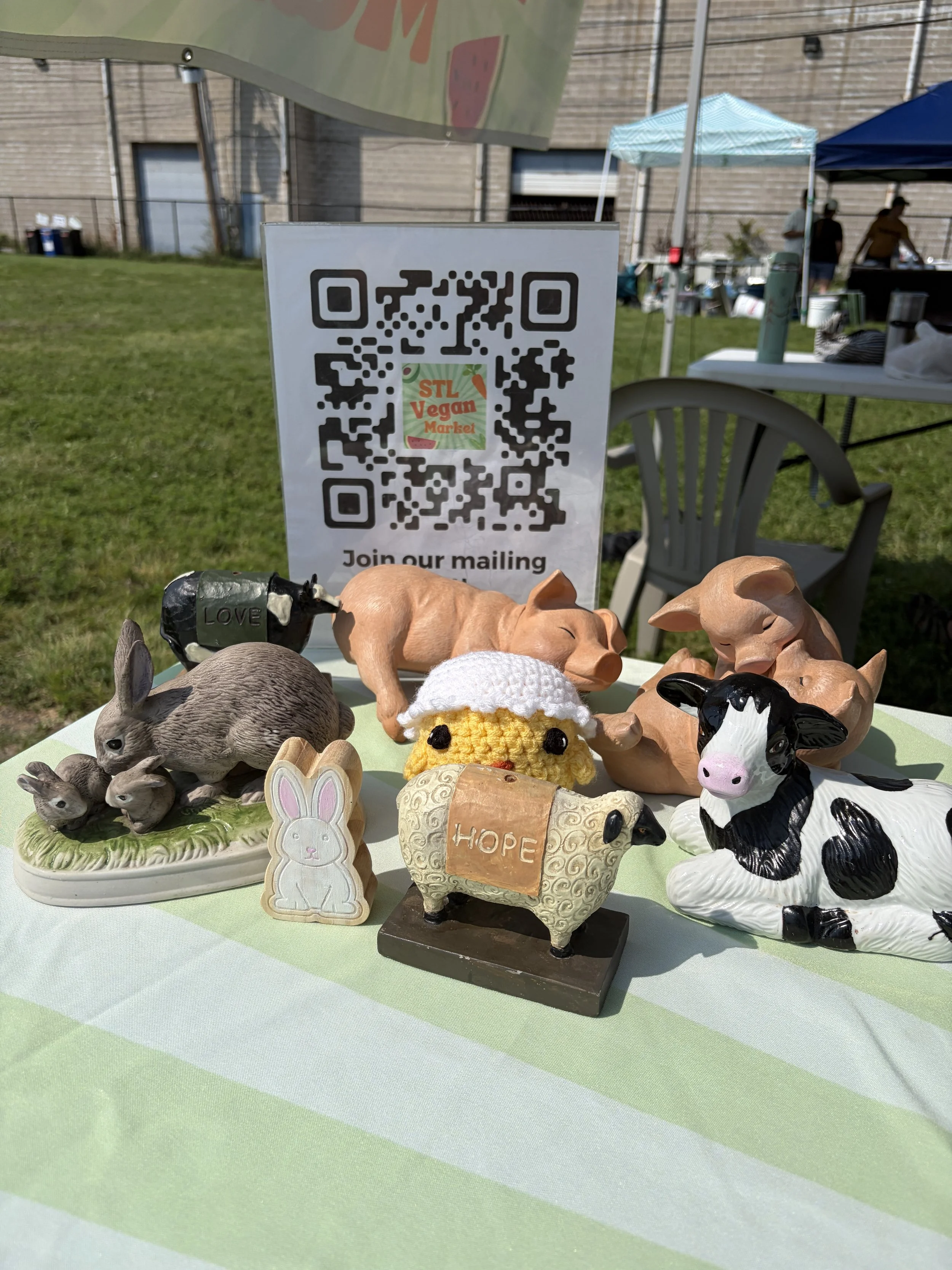 Thrifted farmed animal decorations at Project Animal Freedom_s booth at STL Vegan Market in St. Louis, Missouri.png