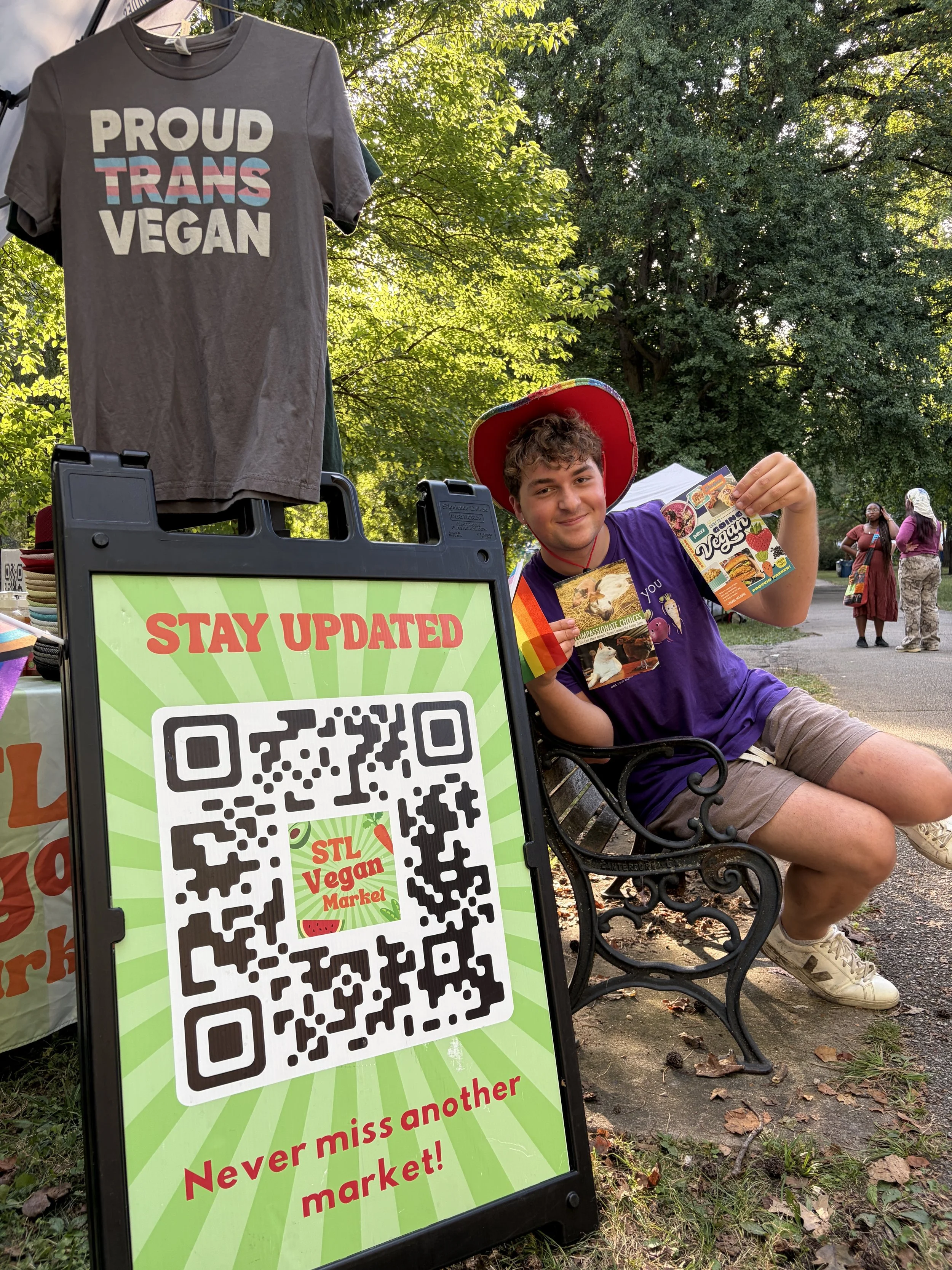 Troy poses on bench for Vegan Pride Booth at Tower Grove Pride in St. Louis, Missouri.png