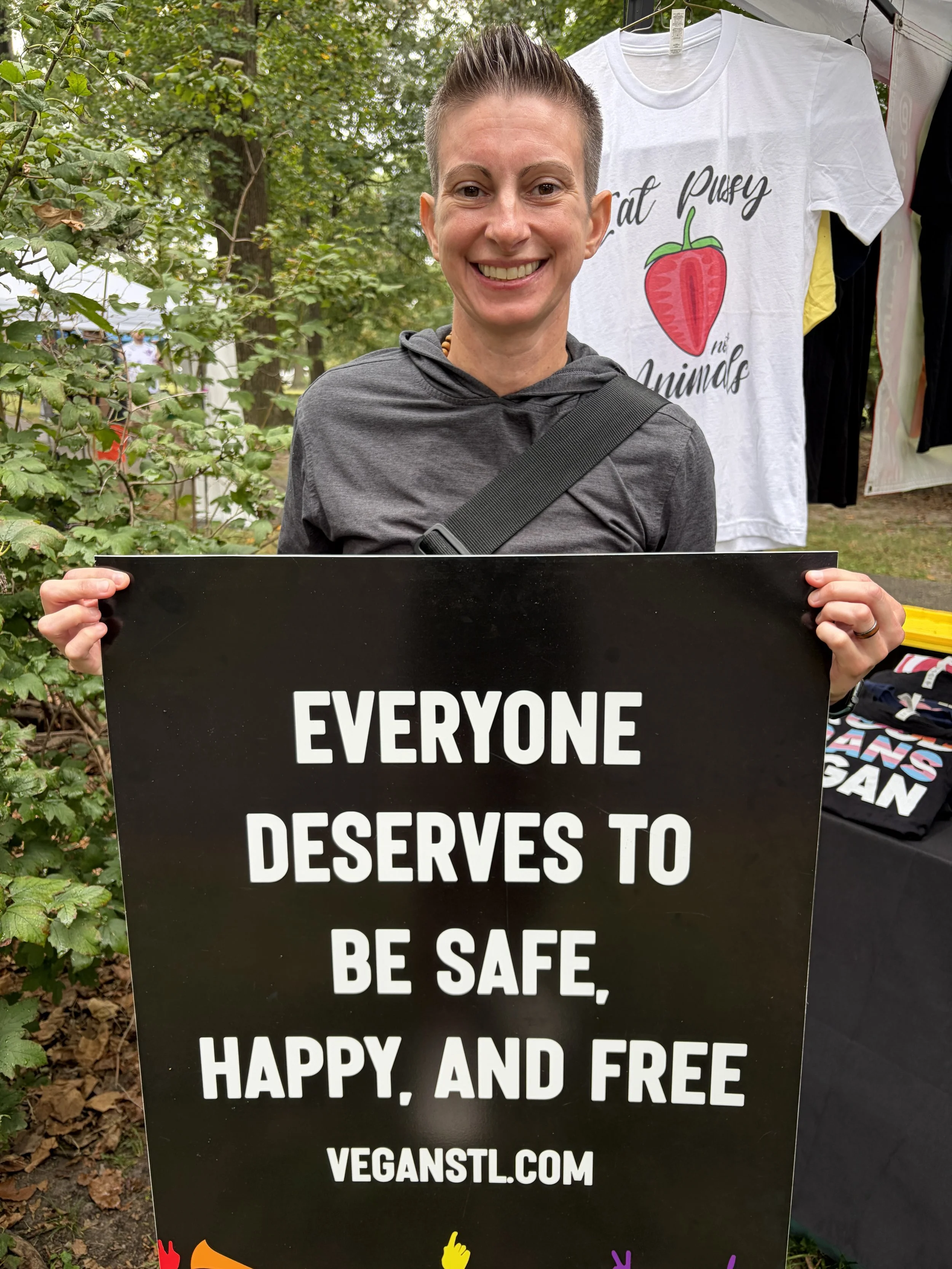 Event visitor proudly holds sign at Vegan Pride Booth at Tower Grove Pride in St. Louis, Missouri.png