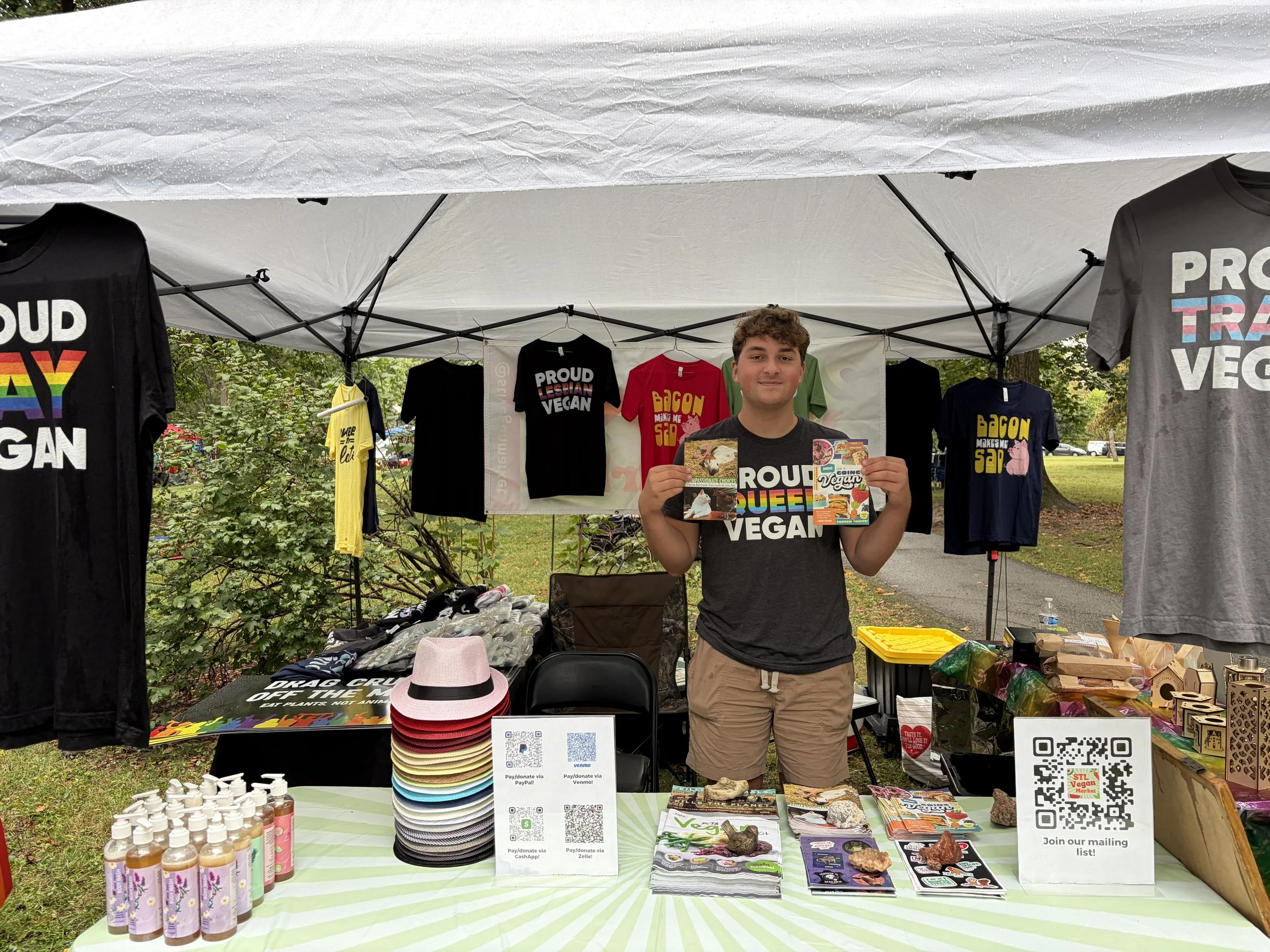 Troy holds literature for Vegan Pride Booth at Tower Grove Pride in St. Louis, Missouri.png