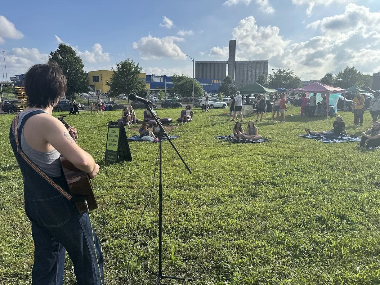 People relaxing and listening to live music at STL Vegan Market