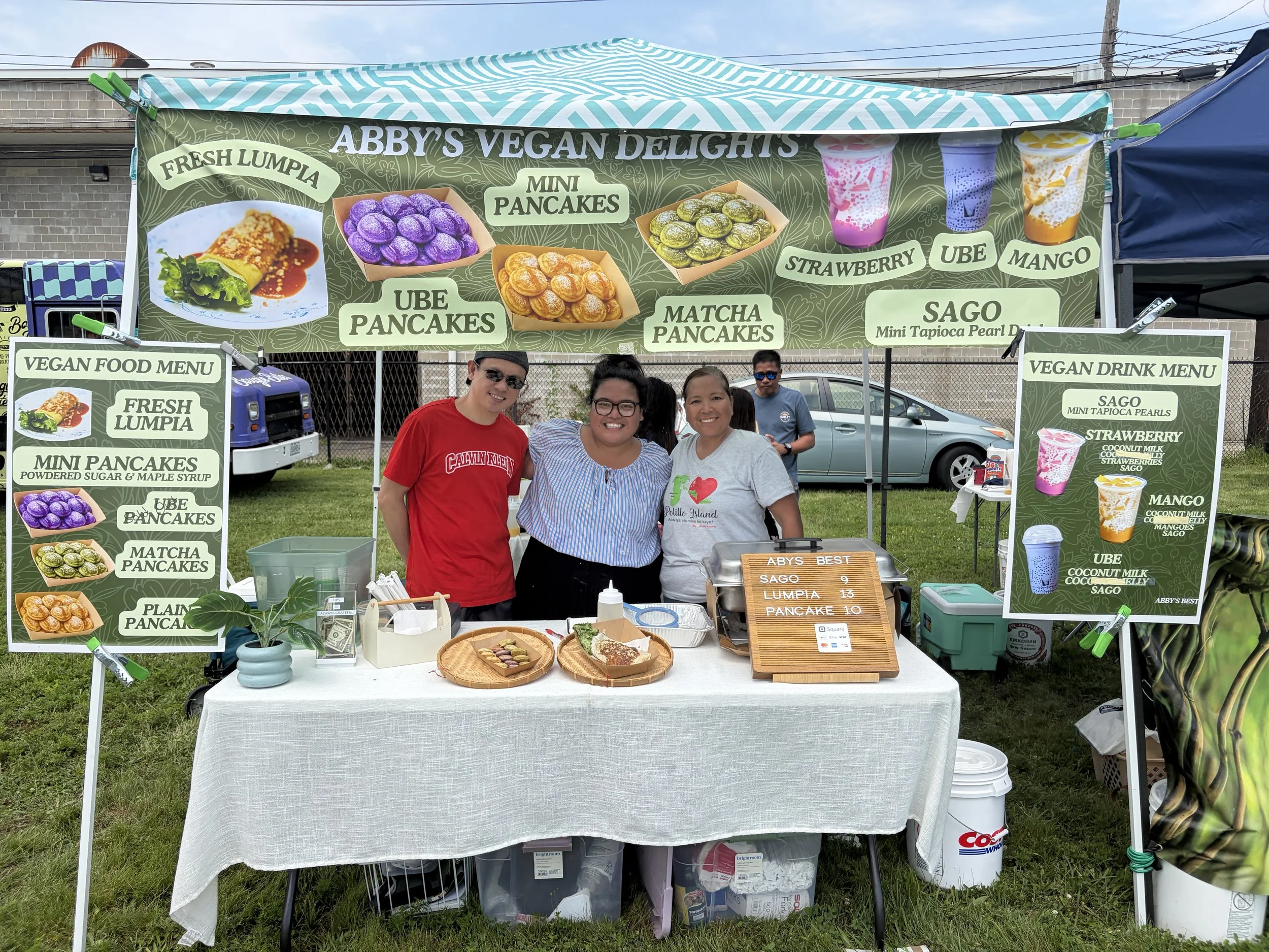 Employees of 100% plant-based business Abby's Vegan Delights happily pose for a photo at STL Vegan Market in St. Louis, Missouri
