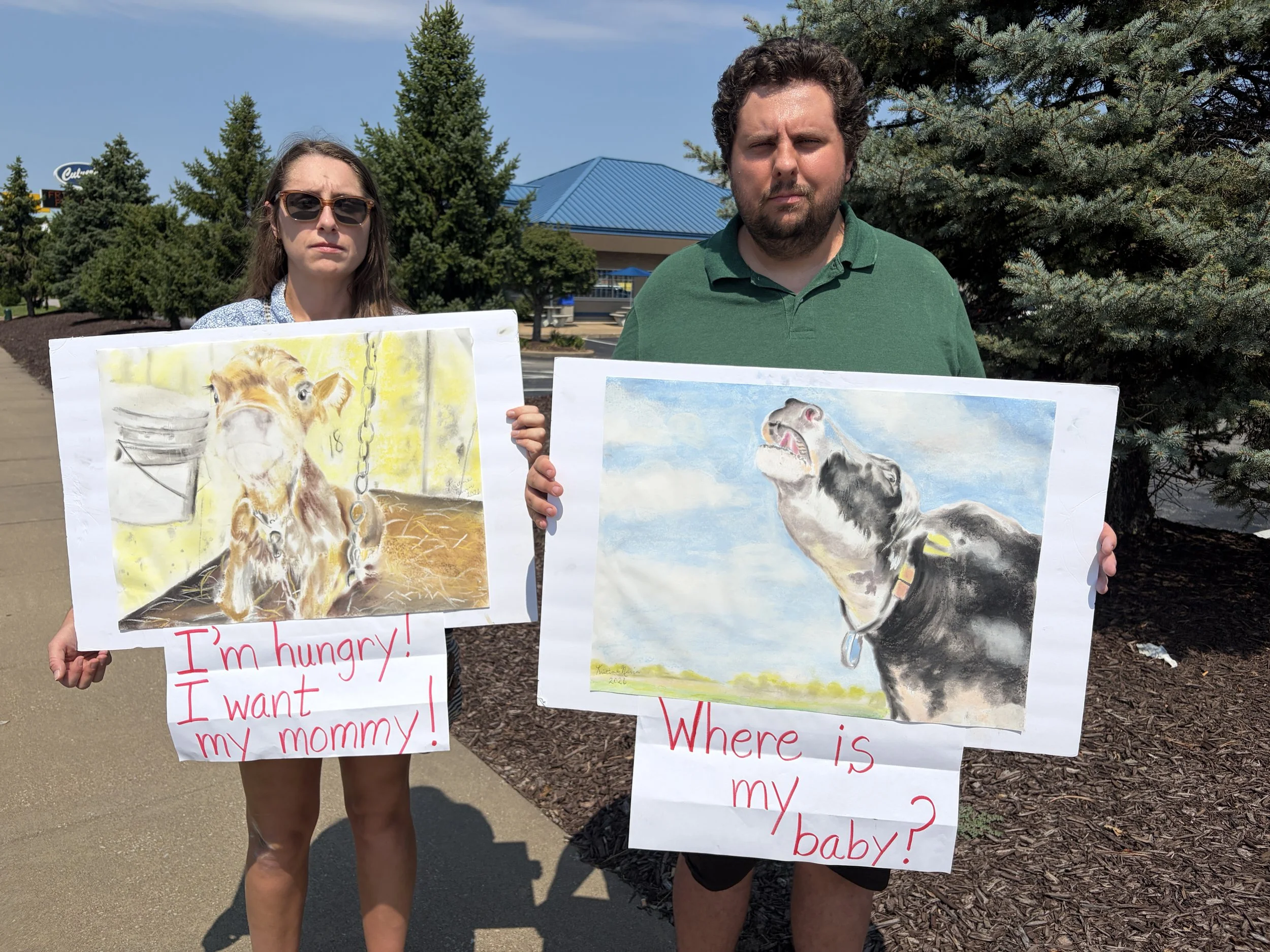 Kyle and Vic hold sad artwork at Dairy Is Scary Protest and Culver's in St. Louis, Missouri