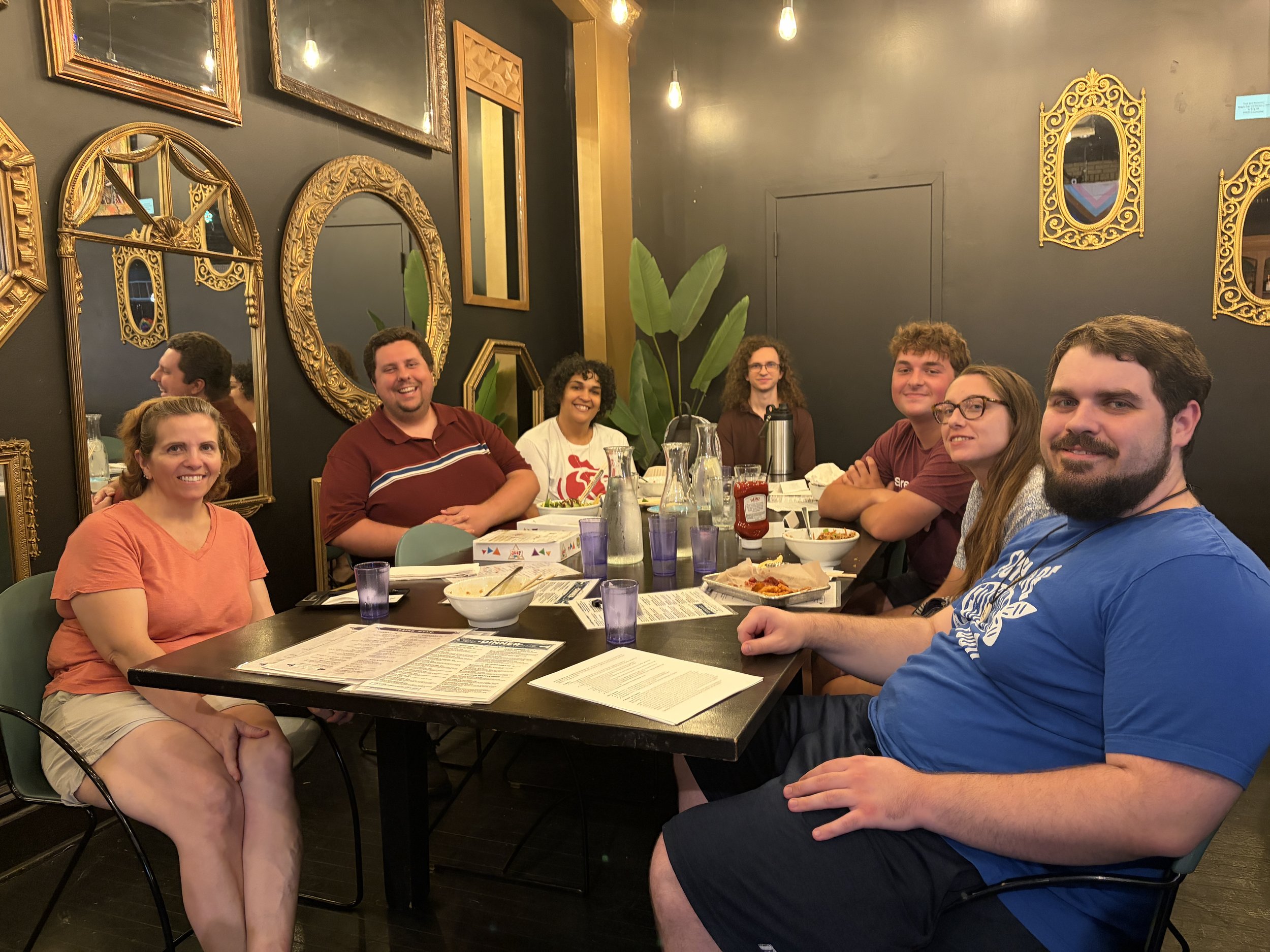 Group of attendees at Vegan Game Night smile for a photo at Pieces in St. Louis, Missouri