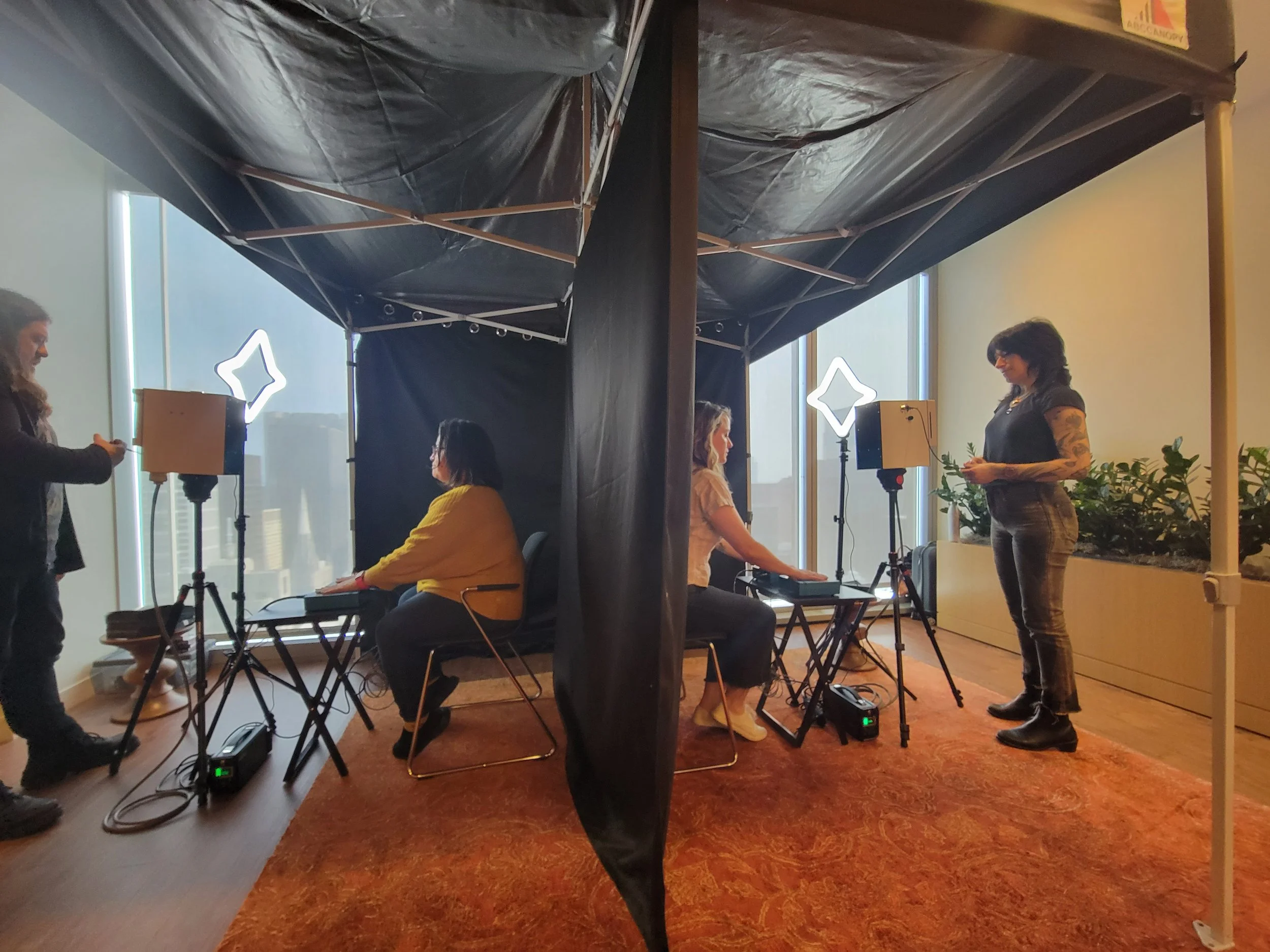 People sitting getting their aura photos taken at an event.