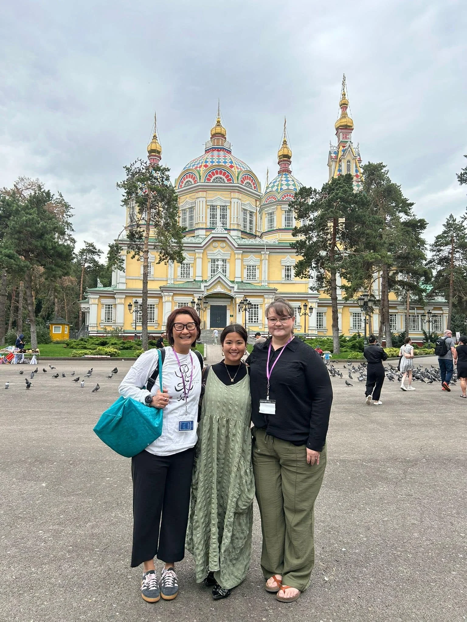 Three woman smile for a photo in Almaty, Kazakhstan.