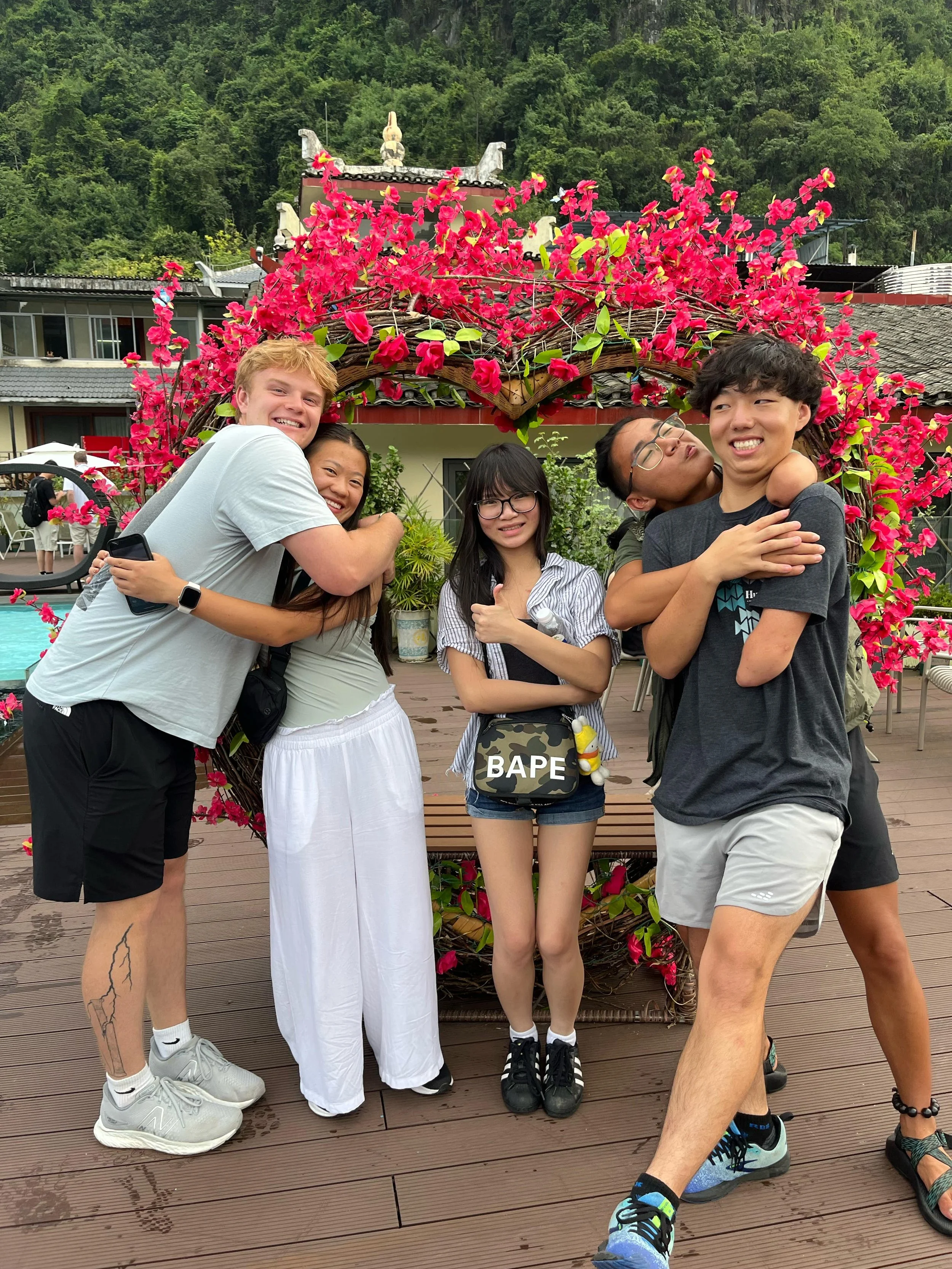 Five young people hug and pose for a photo.