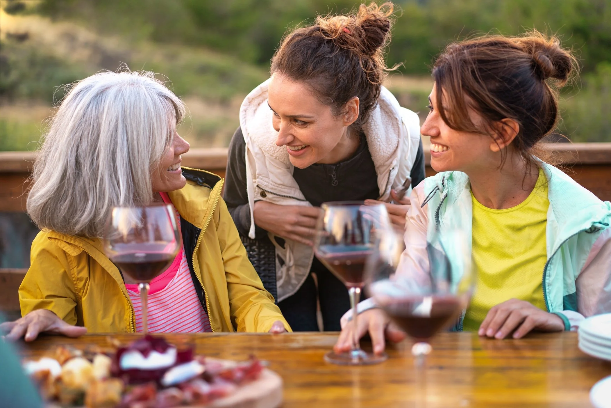 Women enjoying wine, charcuterie, and conversation on a back porch in the Virginia Blue Ridge mountains