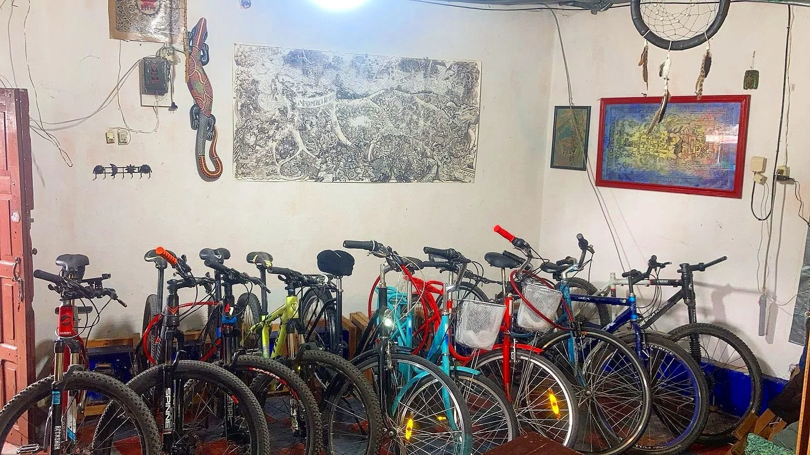Room with multiple bicycles, wall art, dreamcatcher, and various decorations.