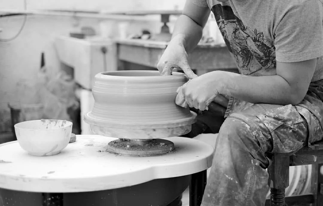 Potter shaping clay on a pottery wheel
