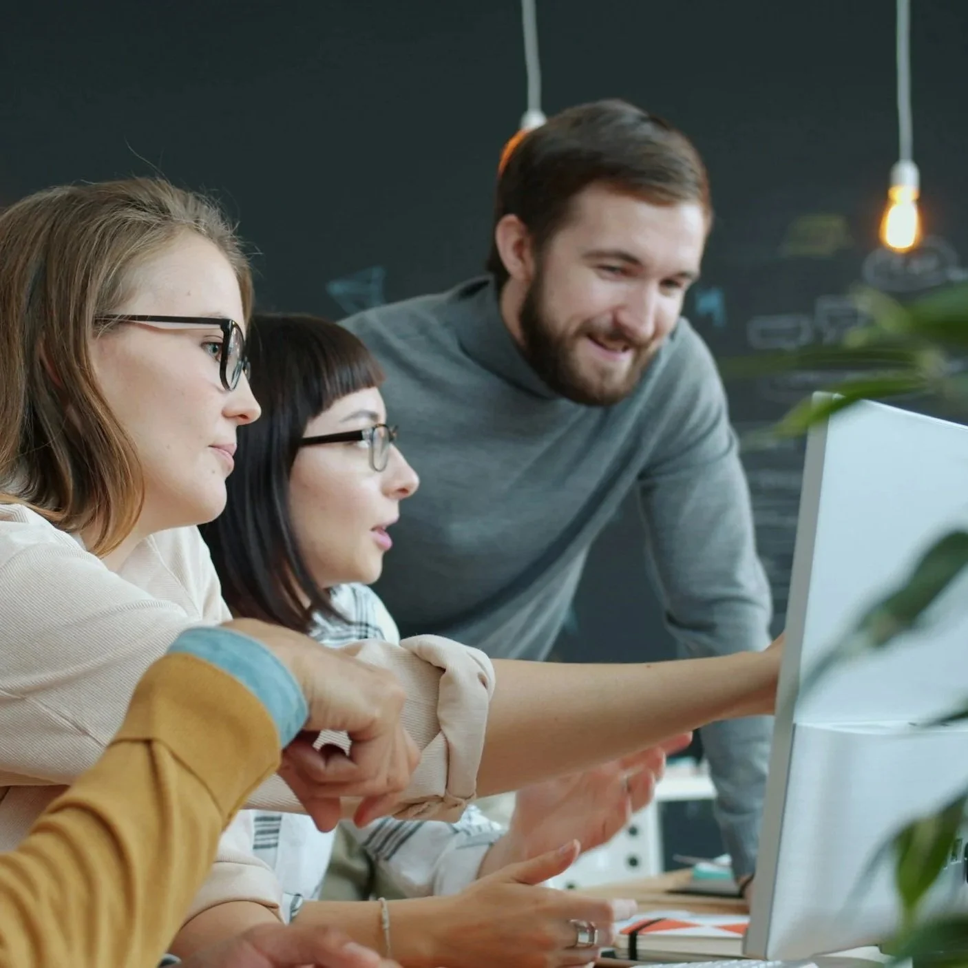 A group of business professionals collaborating around a computer screen during a QuickBooks bookkeeping coaching and training session.