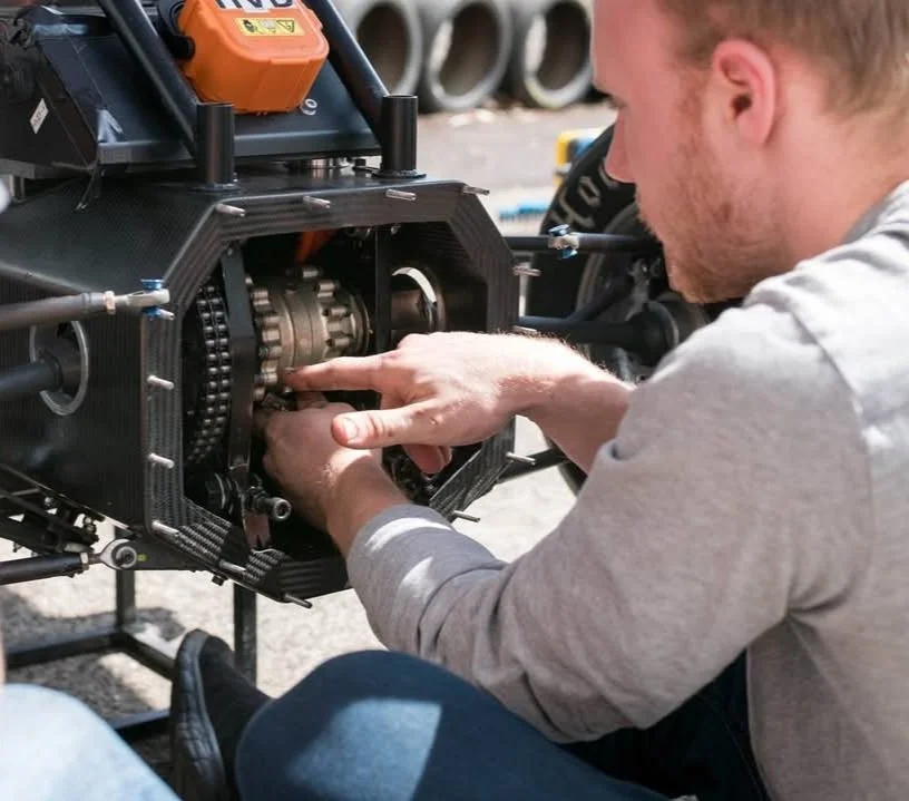 Person working on a mechanical engine component.
