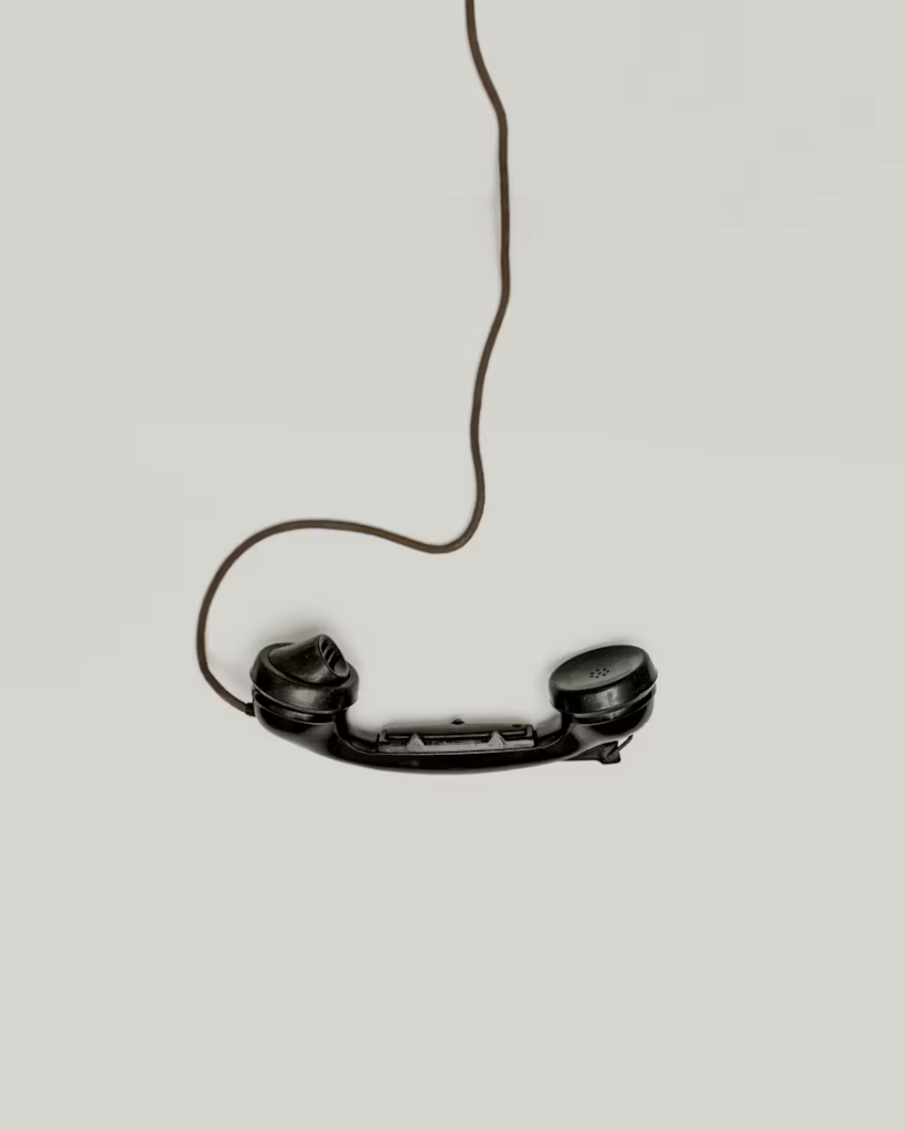 Vintage telephone receiver with cord on white background