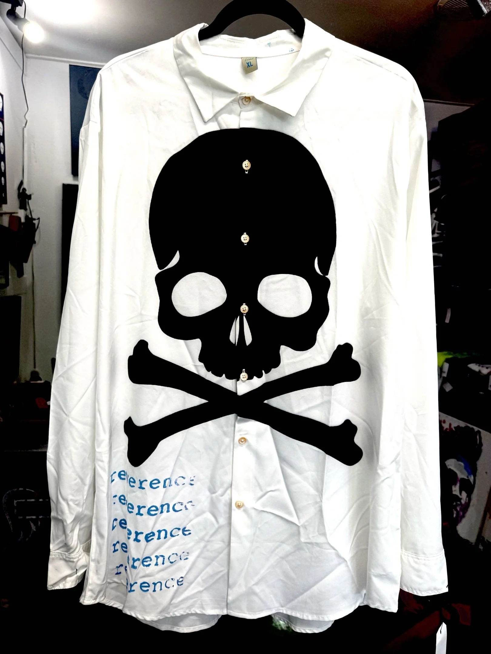 reverence delinquent long-sleeved white collared shirt with large black skull print and blue reverence text (front)