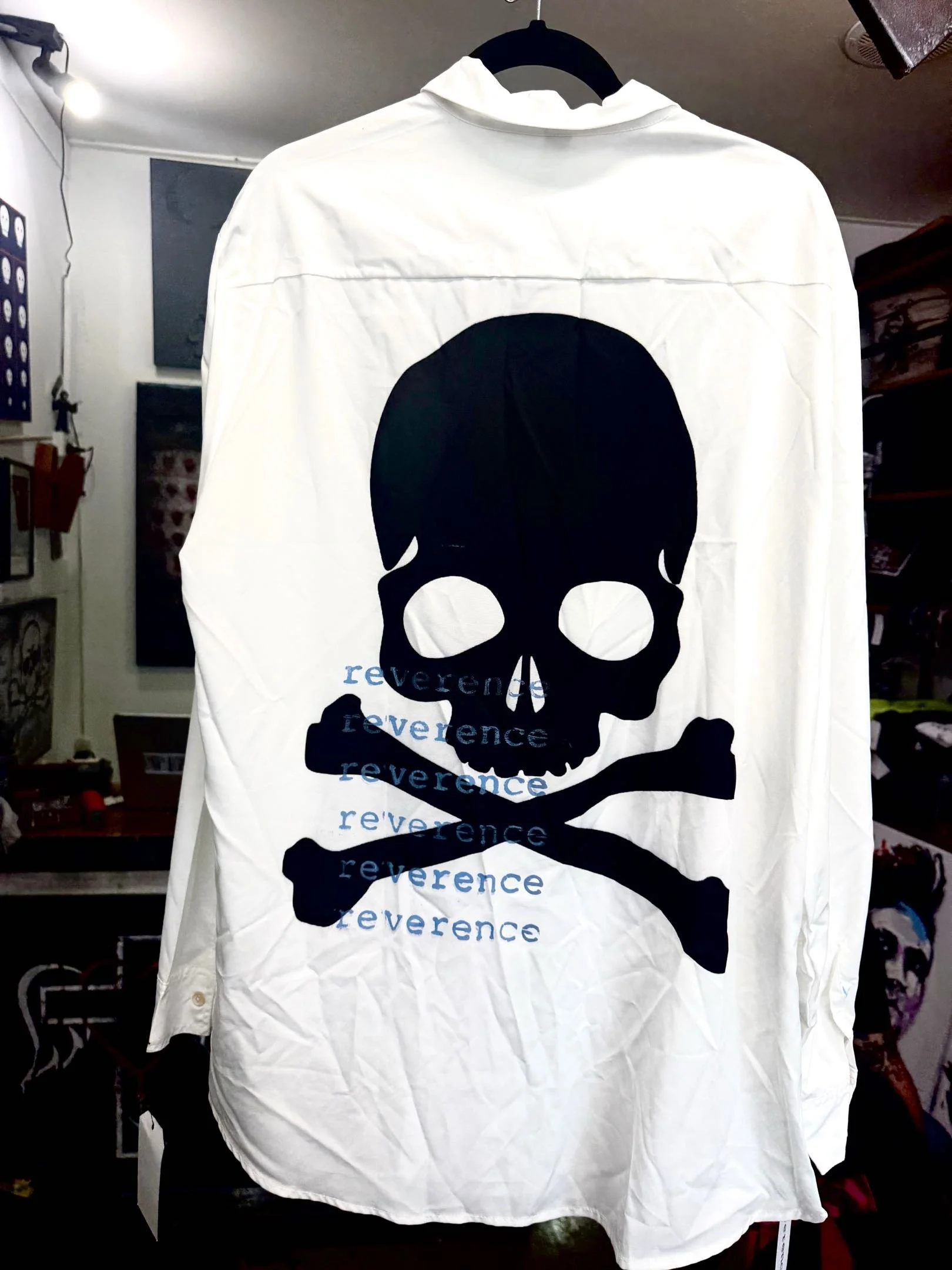 reverence delinquent long-sleeved white collared shirt with large black skull print and blue reverence text (back)