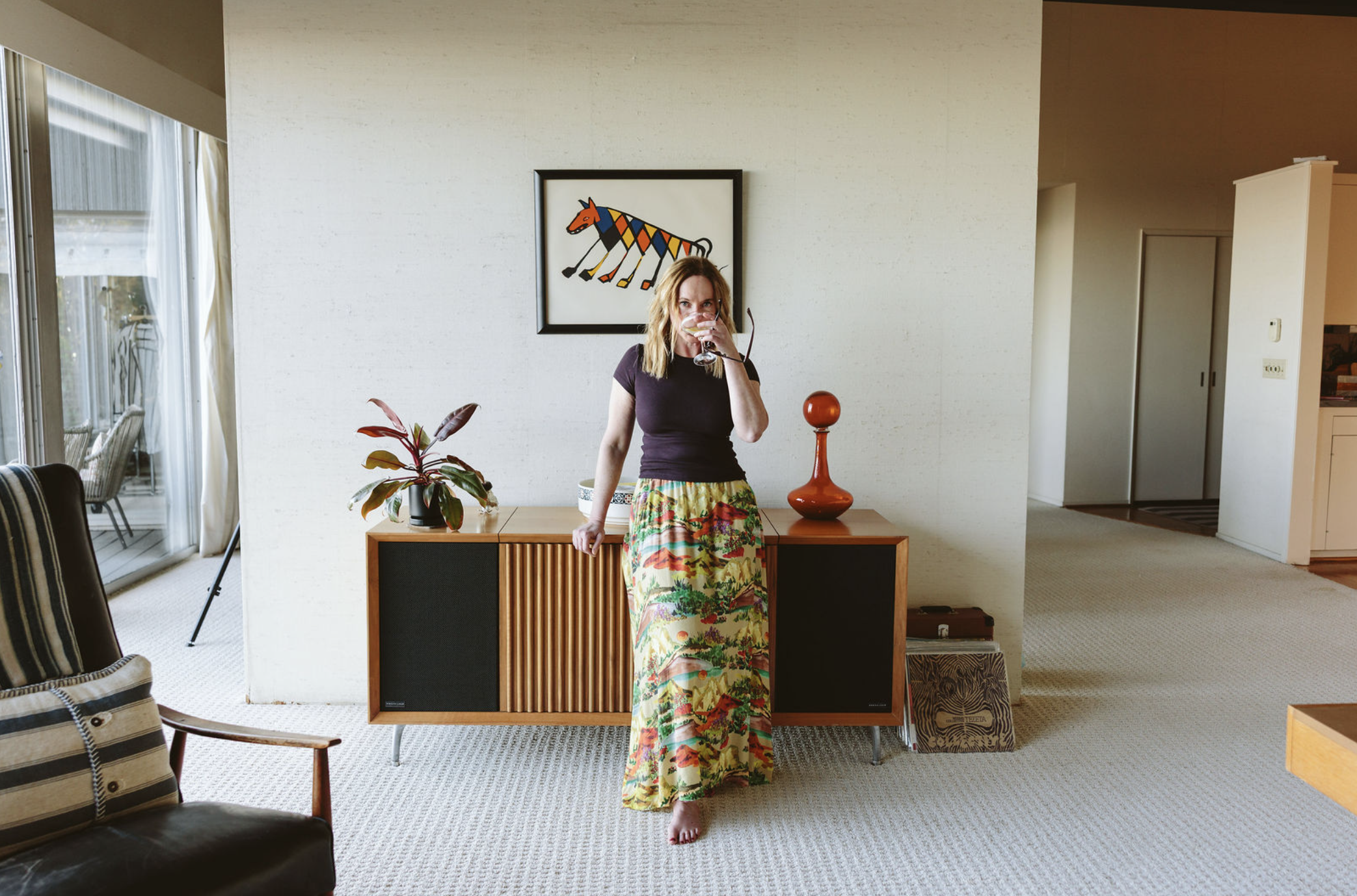 Chloe Ruth Johnson standing in a room, wearing a brightly colored long skirt.