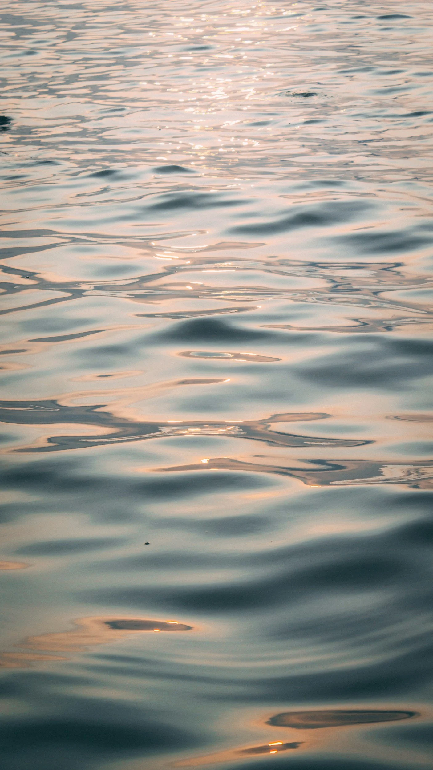 Sunlight reflecting off the rippling surface of a body of water, creating a shimmering, golden effect.