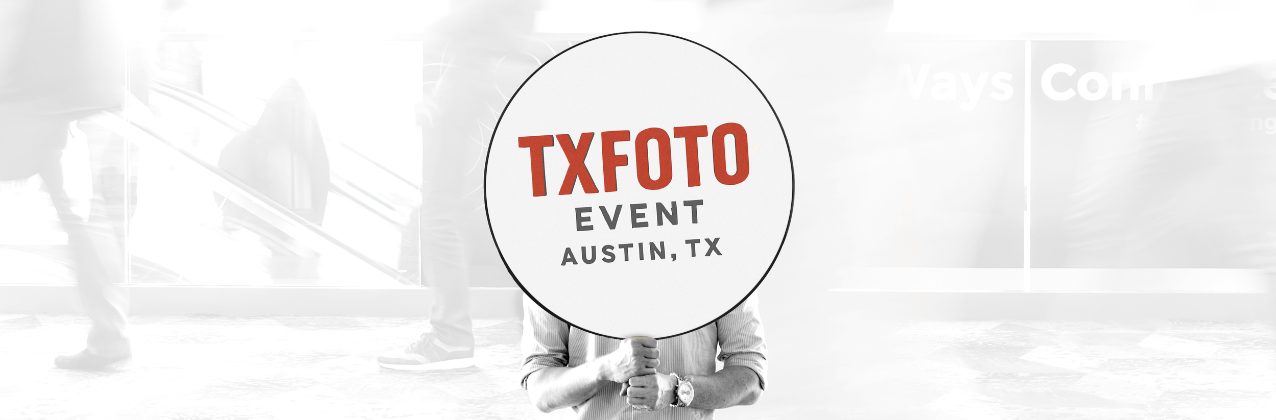 Person holding a sign that reads 'TXFOTO EVENT AUSTIN, TX' at an event in Austin, Texas.