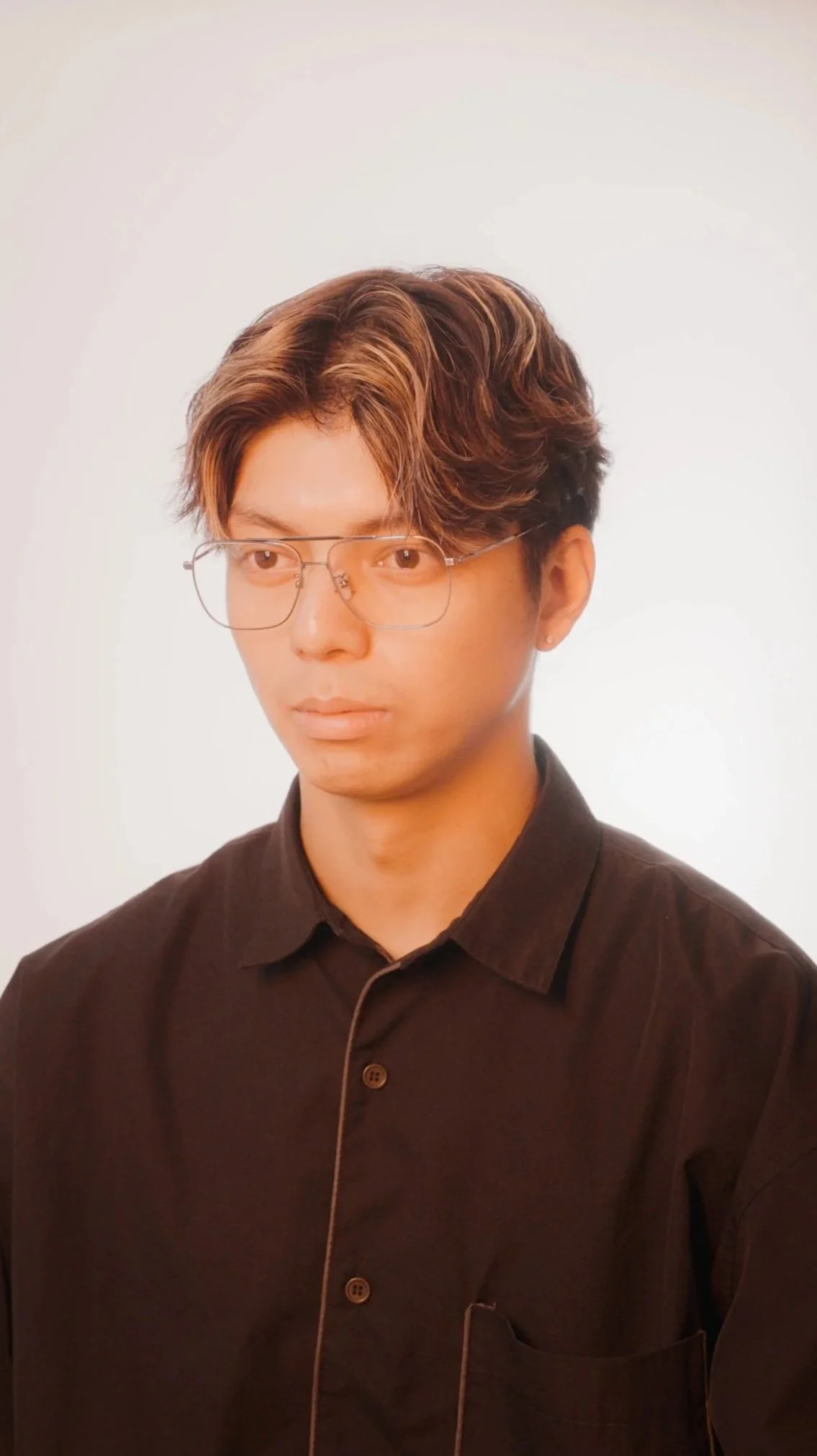 映像ディレクター 富永のポートレート写真。黒いシャツを着用している。