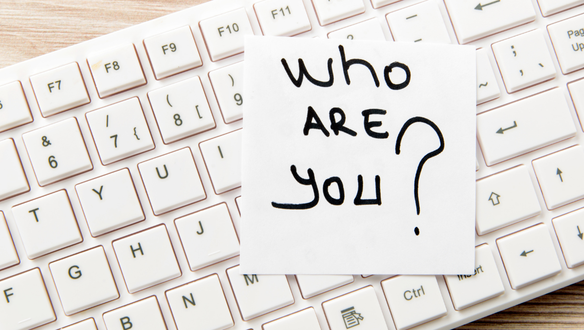 A post-it note on a keyboard reads, "Who are you?"