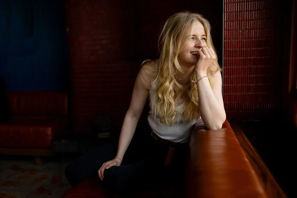 Brand copywriter Emma Griffin sitting on leather sofa thinking about messaging strategy