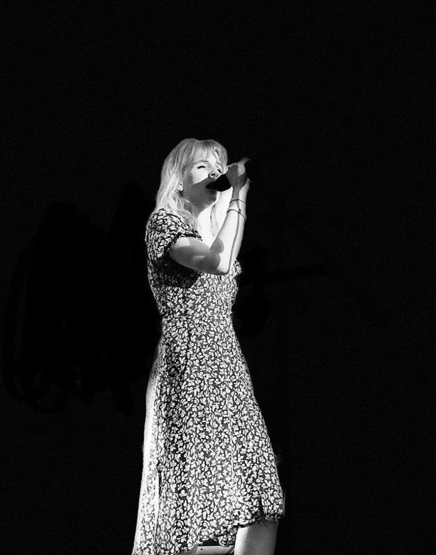 Black and white photo of Emma Griffin singing and performing– creative UK copywriter and hook marketing strategist