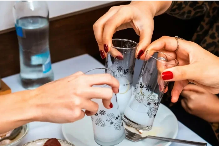 Menschen stoßen mit Gläsern an, die auf einem Tisch stehen, um einen Toast zu machen.