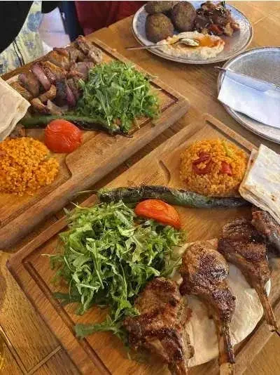 Gericht mit gegrilltem Fleisch, Hühnchenspießen, grünen Salat, Tomate, Reis und eine andere Platte mit Fleischbällchen und wahrscheinlich Sauce