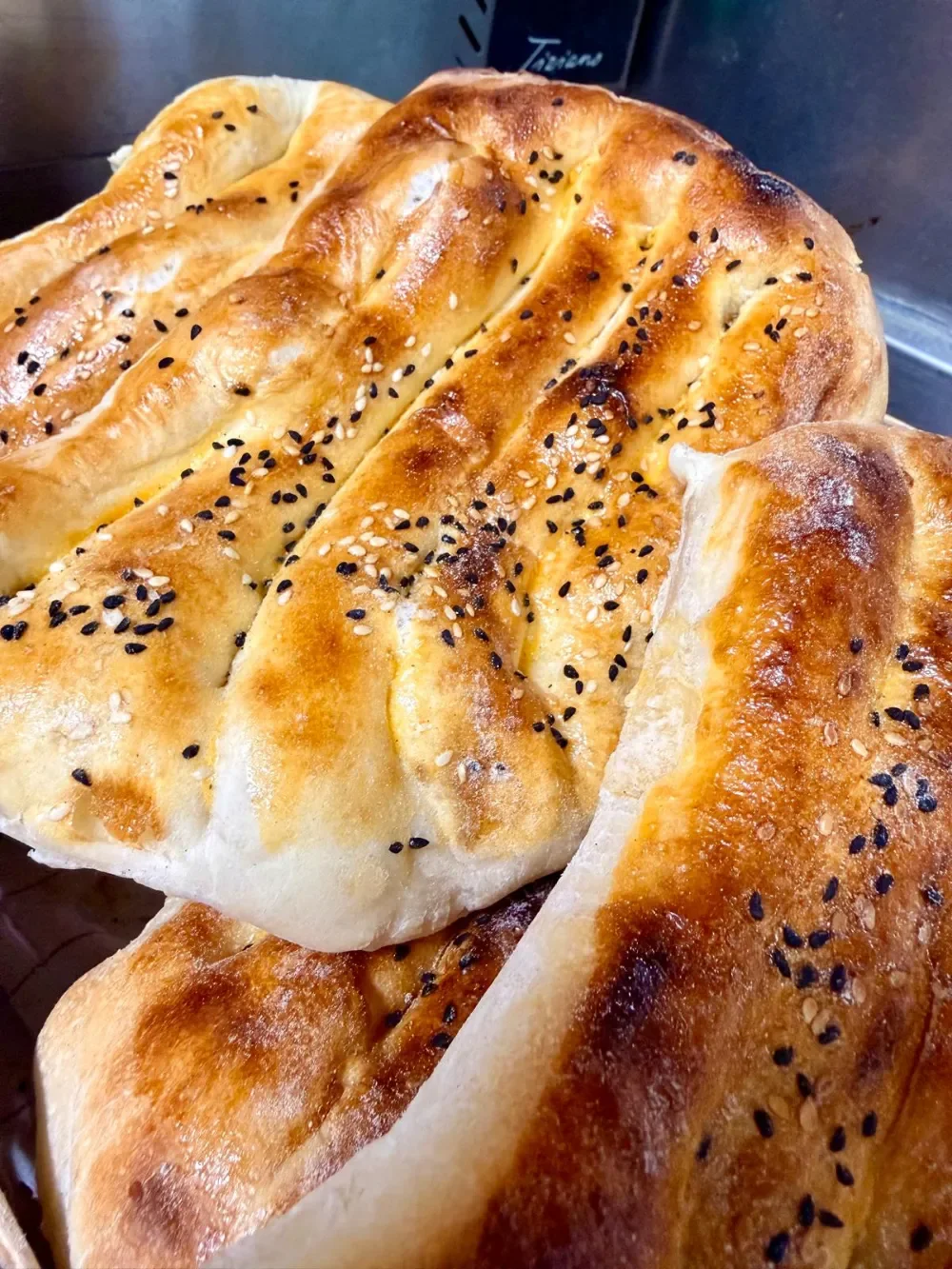 Frische, goldbraun gebackenes Pidebrot mit Sesam- und Schwarzkümmelsamen bestreut