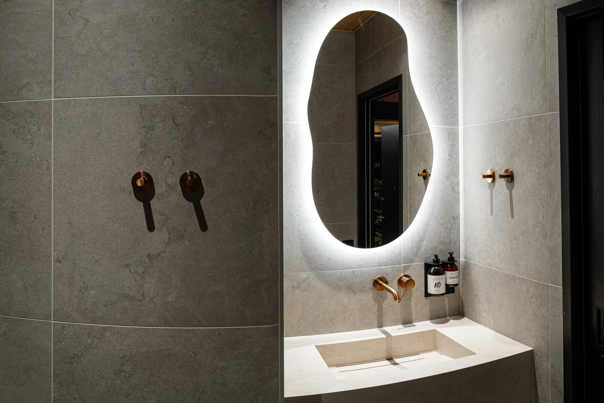 Kylpyhuoneen peili ja käsisuihku.