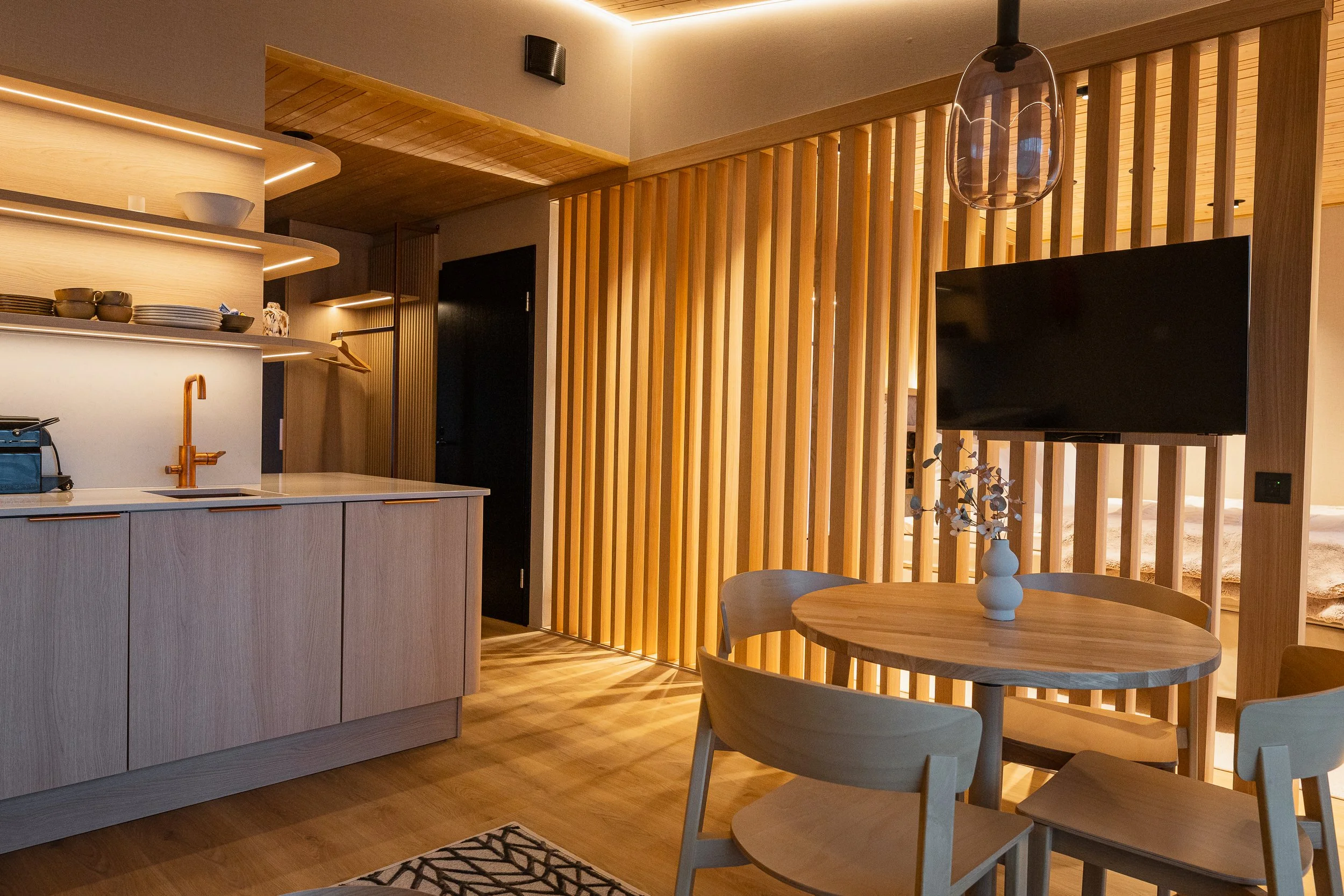 Skandinaavin tyylinen ruokailu- ja keittiöalue, puukasistukset ja moderni sisustus.