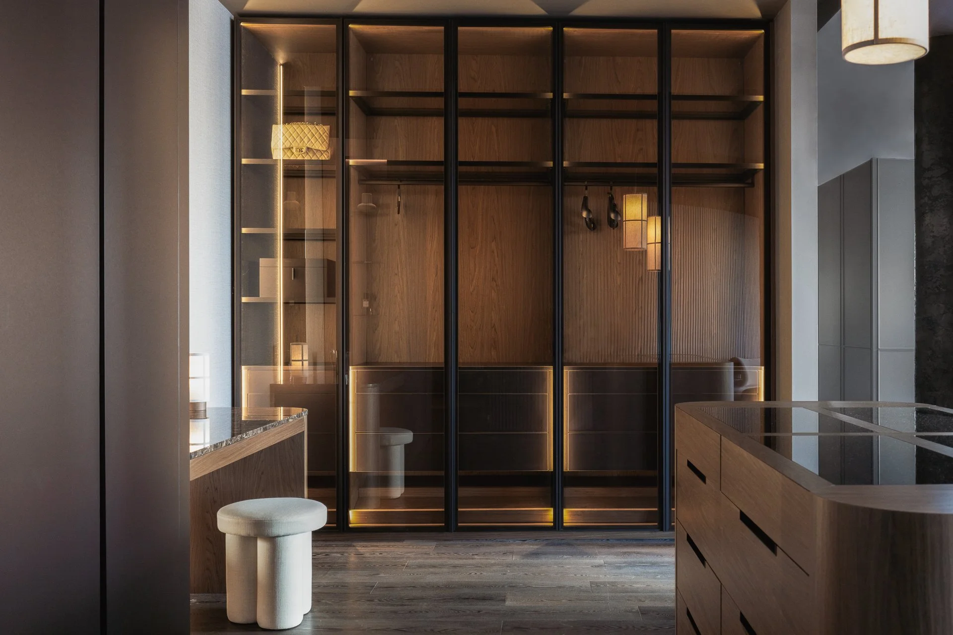 Modern kitchen with wooden cabinetry, a glass-paneled partition, and ambient lighting.