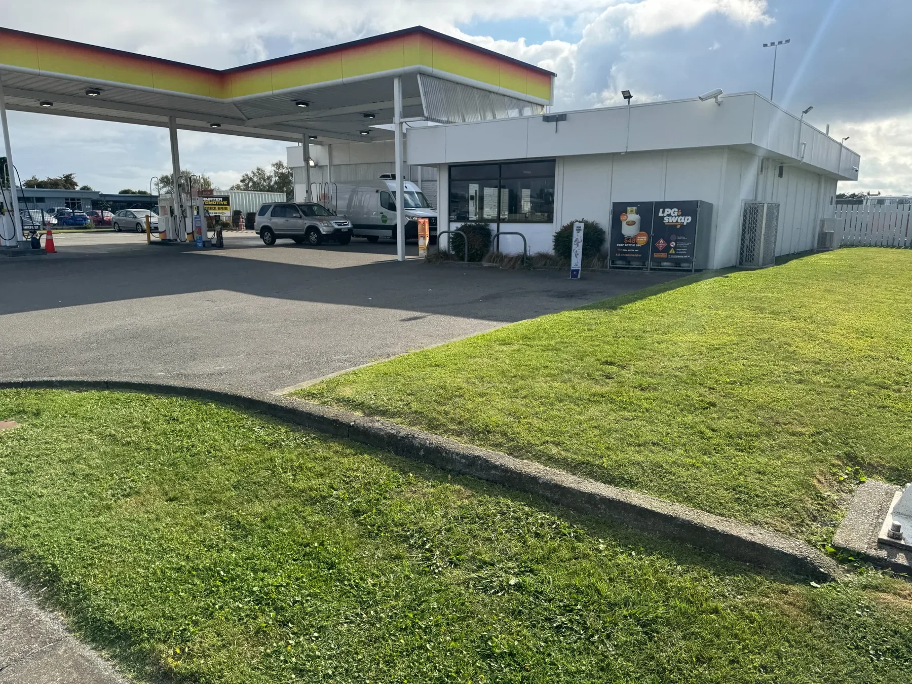 Mown grass and maintained grounds beside a service station