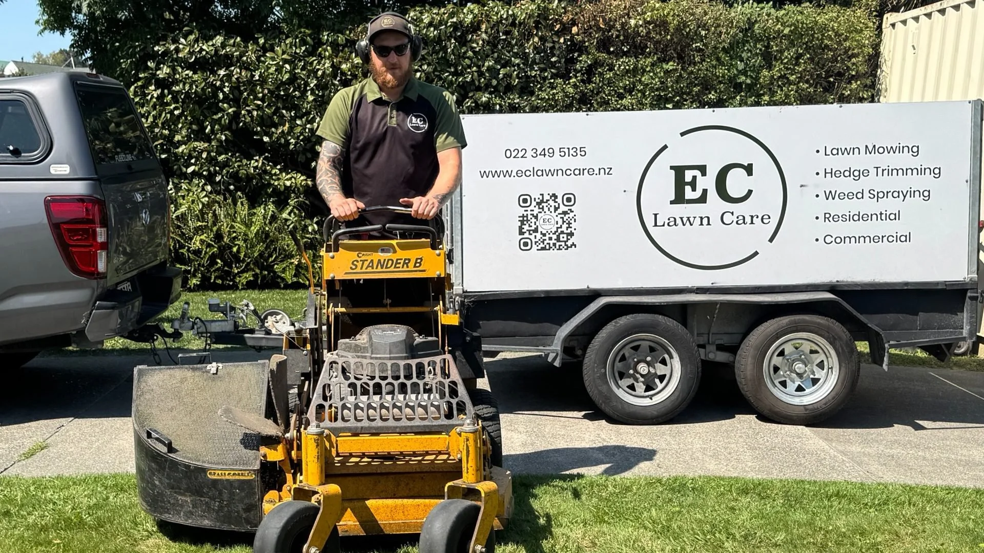 EC Lawn Care operator with professional mowing equipment and branded trailer in Hawke’s Bay.