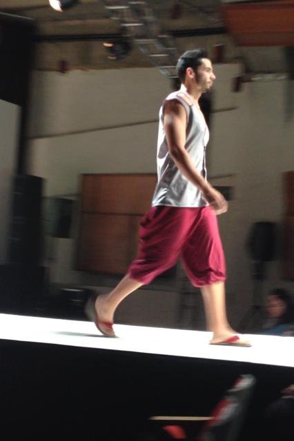 Model walking on a runway during a fashion show.