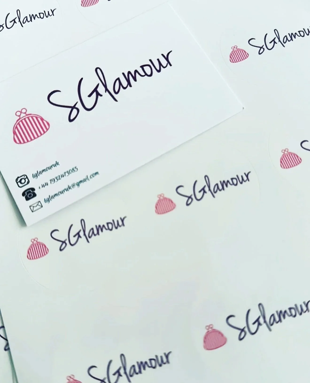 Business cards with the logo 'sGlamour', a pink purse icon, and contact information, printed on white paper.