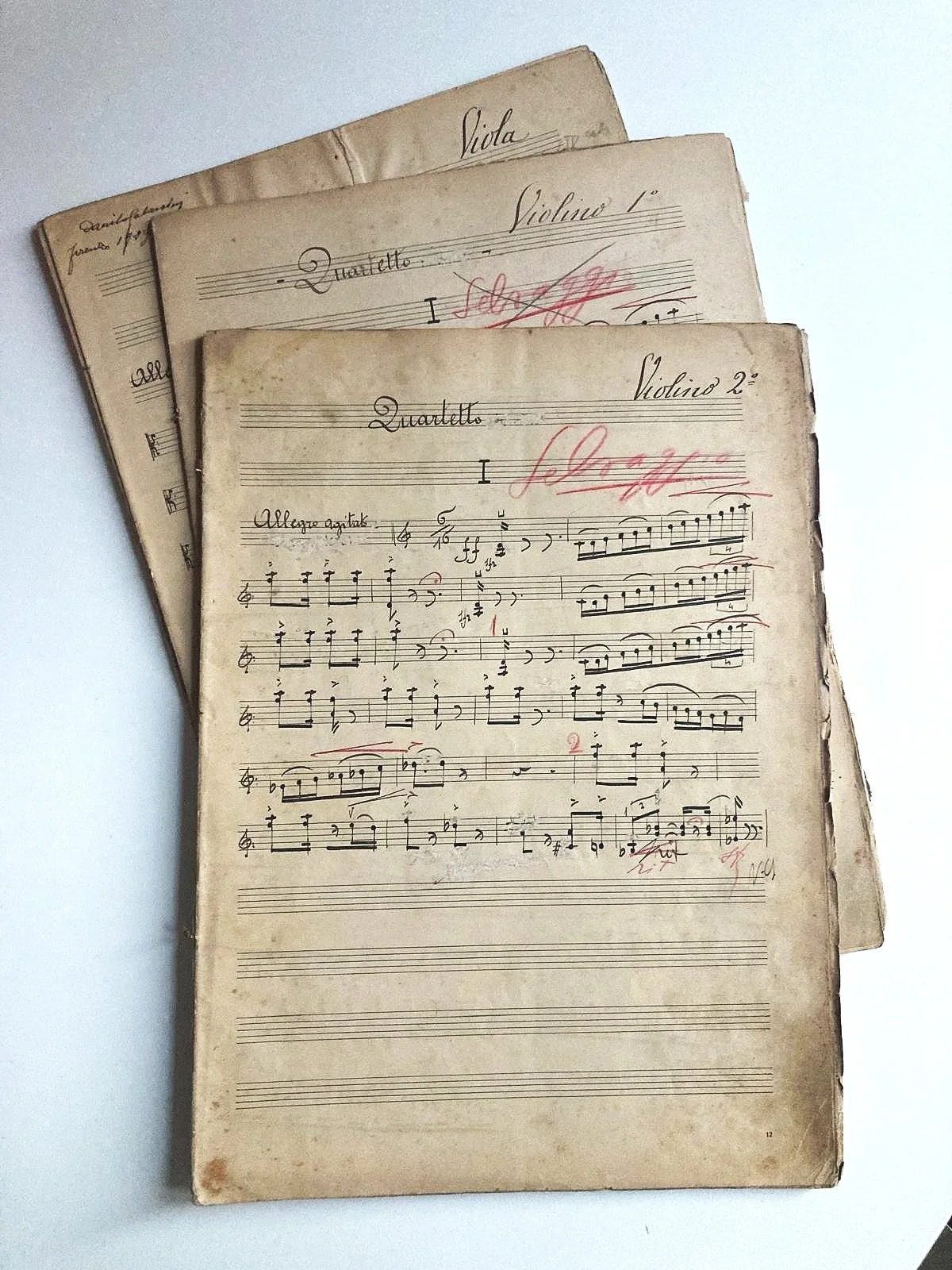 Tre pagine di partiture musicali scritte a mano con annotazioni e sovrapposizioni di vecchie note.