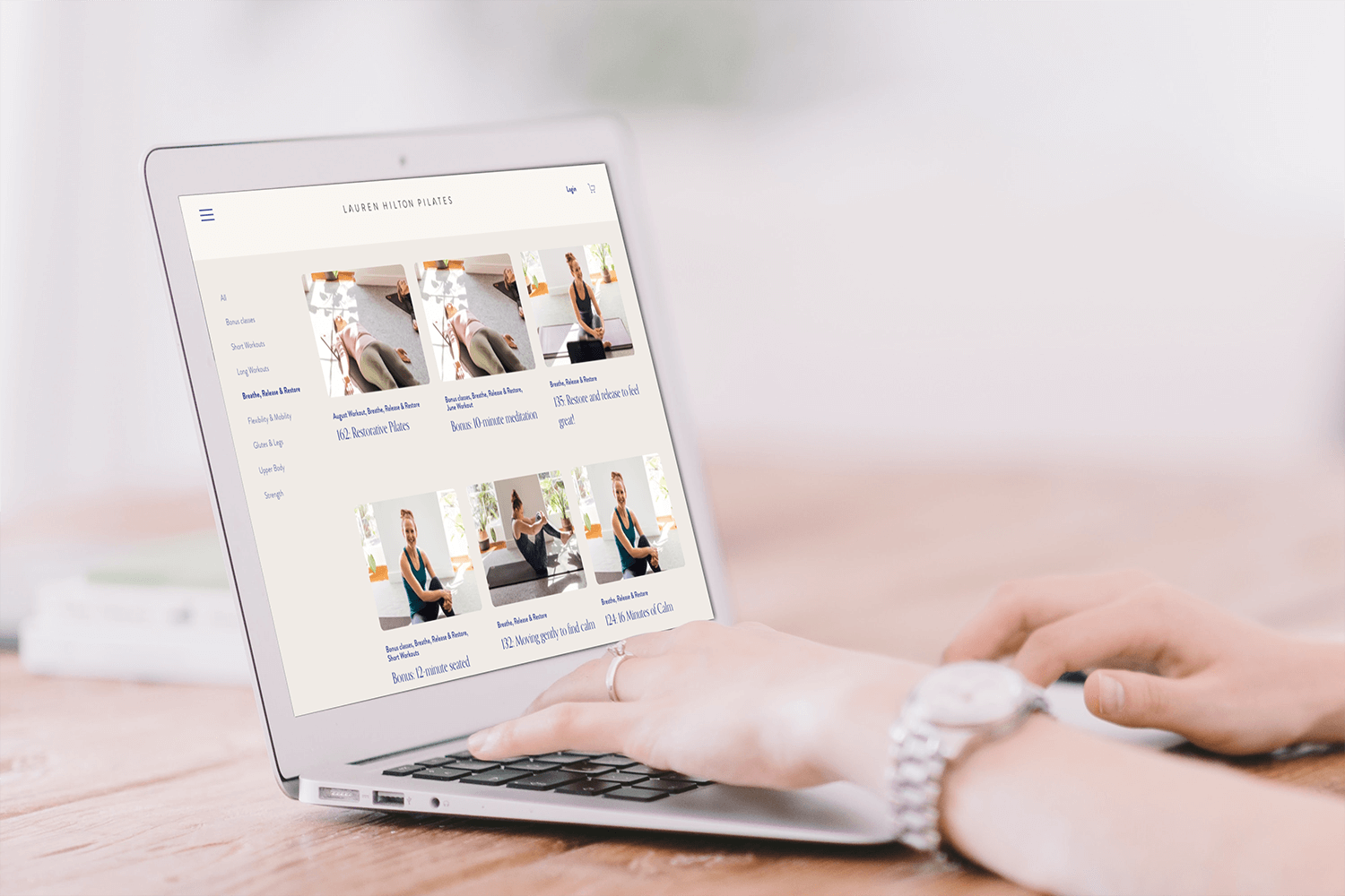 Someone browsing Pilates At Home on a laptop