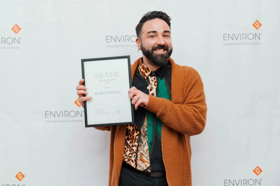 Person holding a framed certificate at an Environ event.