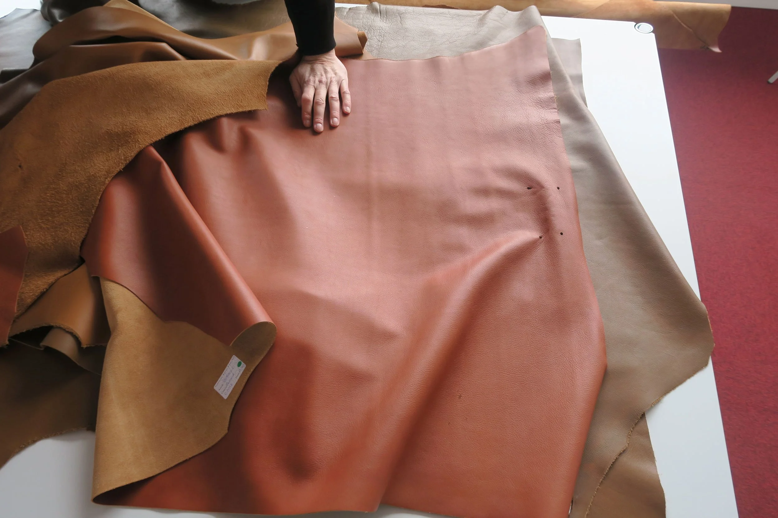 Personne devant des rouleaux de cuir dans un atelier d'ameublement