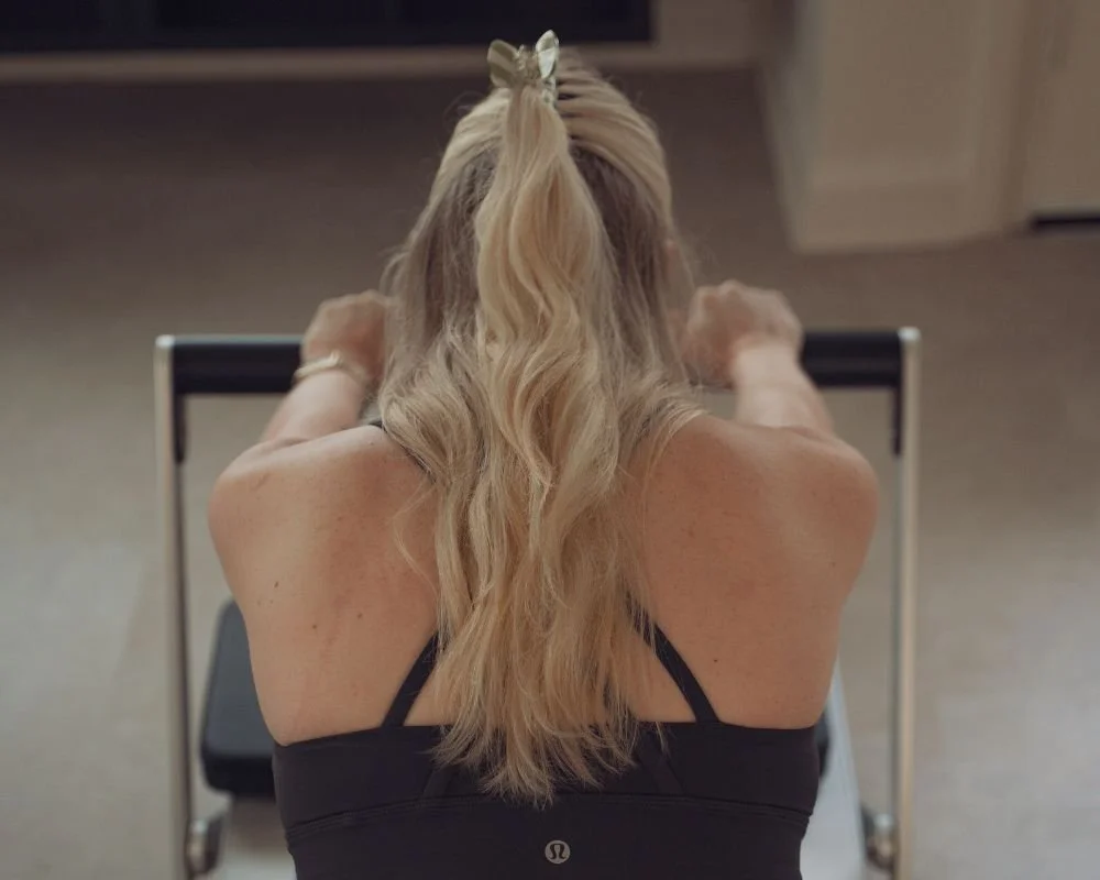 Back view of a client gently gripping the reformer during a Sojourn Pause class at the Broughton Astley studio.