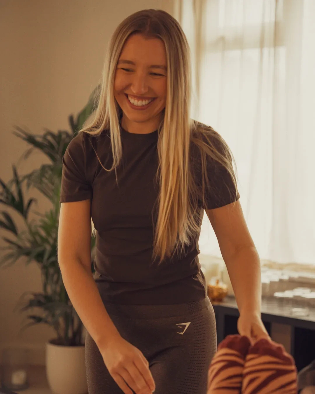 Jess, Sojourn Pilates Lead Instructor in Broughton Astley, smiling before teaching the Garden-View outdoor mat Pilates class in Leicestershire.